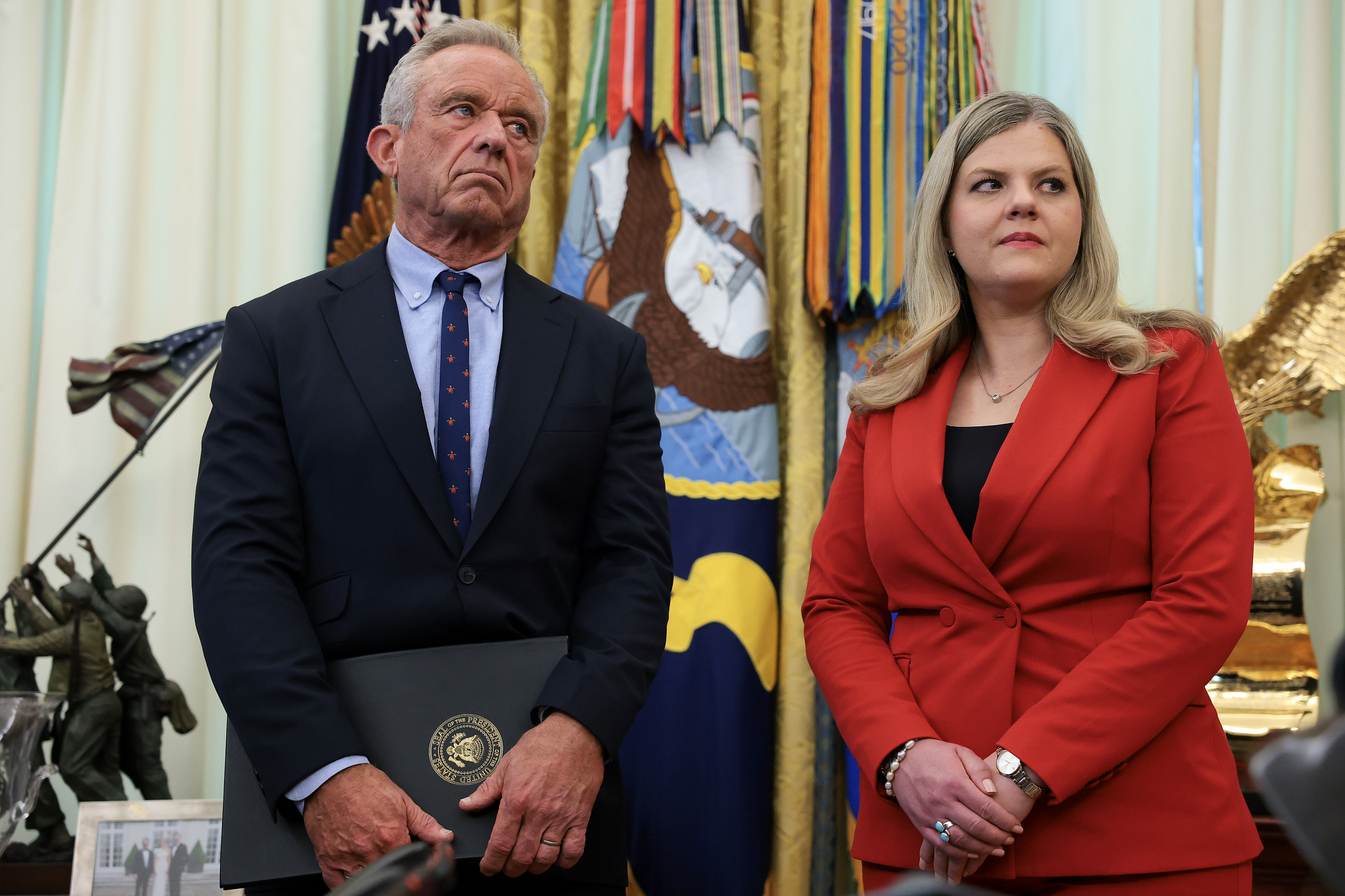 Health and Human Services Secretary Robert F. Kennedy Jr. (L), and Deputy Assistant to the President for Domestic Policy Dr. Heidi Overton (R), stand in the Oval Office after U.S. President Donald Trump signed an executive order calling for childhood vaccine shots to be spaced out into separate visits at the White House on August 10, 2026 in Washington, DC. (Photo by Anna Moneymaker/Getty Images)