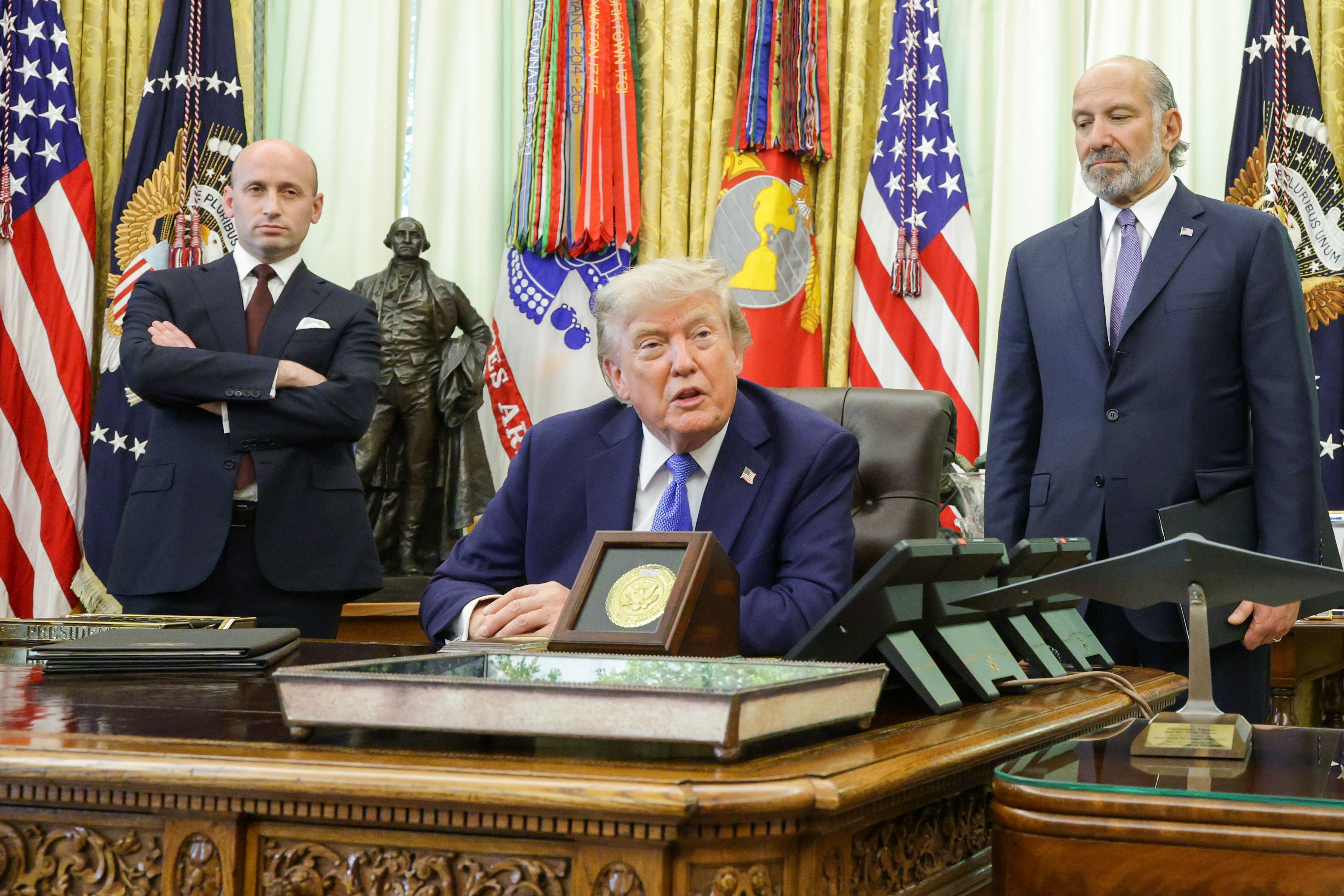 WASHINGTON, DC - AUGUST 06: U.S. President Donald Trump (C) speaks as White House Deputy Chief of Staff and Homeland Security Advisor Stephen Miller (L) and U.S. Commerce Secretary Howard Lutnick look on during an event in the Oval Office of the White House on August 06, 2026 in Washington, DC.  President Trump is expected to sign two executive orders on bringing computer chip manufacturing to the U.S. and denying birthright citizenship to children of foreign diplomats. (Photo by Alex Wong/Getty Images)