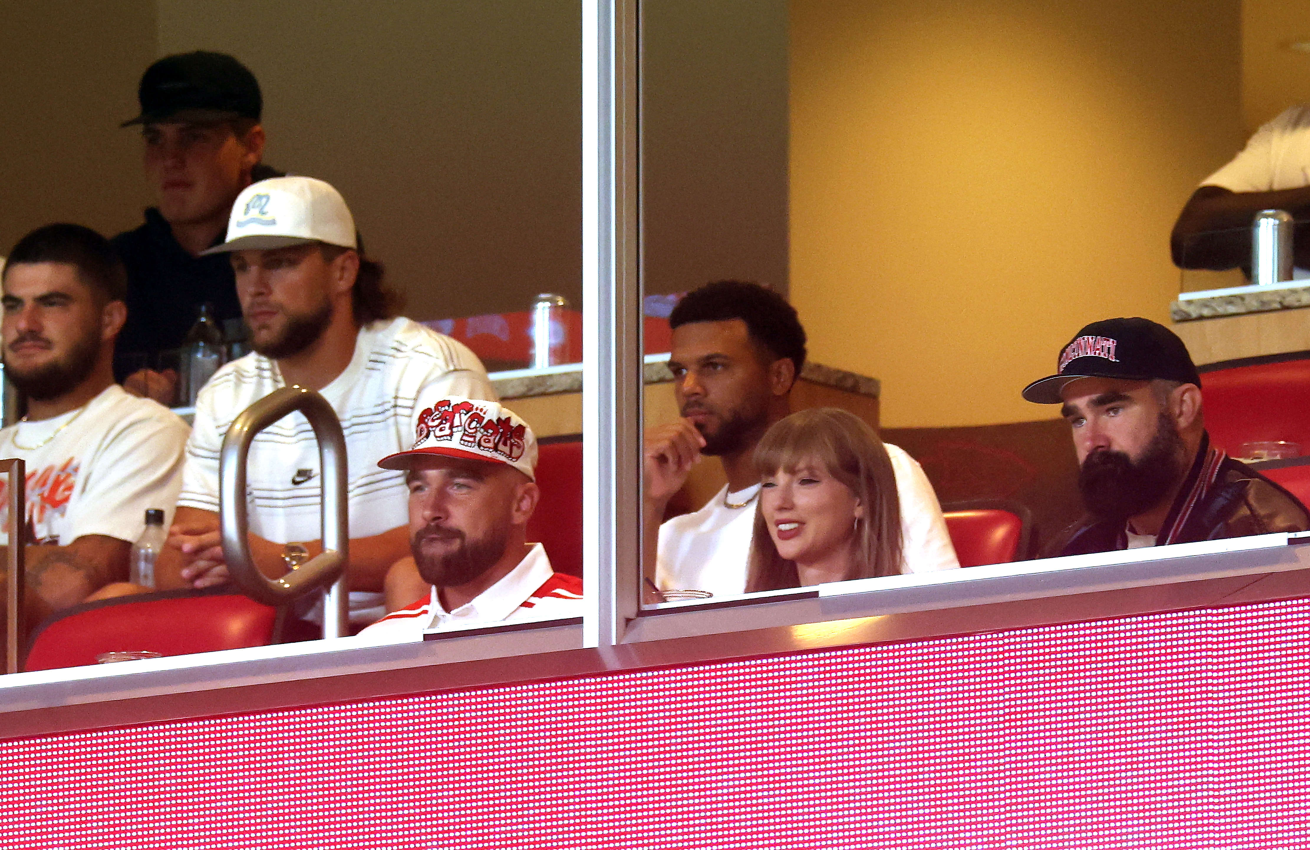 KANSAS CITY, MISSOURI - AUGUST 28:  Travis Kelce #87 of the Kansas City Chiefs, Taylor Swift and Jason Kelce watch during the first half of the game between the Cincinnati Bearcats and the Nebraska Cornhuskers at Arrowhead Stadium on August 28, 2025 in Kansas City, Missouri. (Photo by Jamie Squire/Getty Images)
