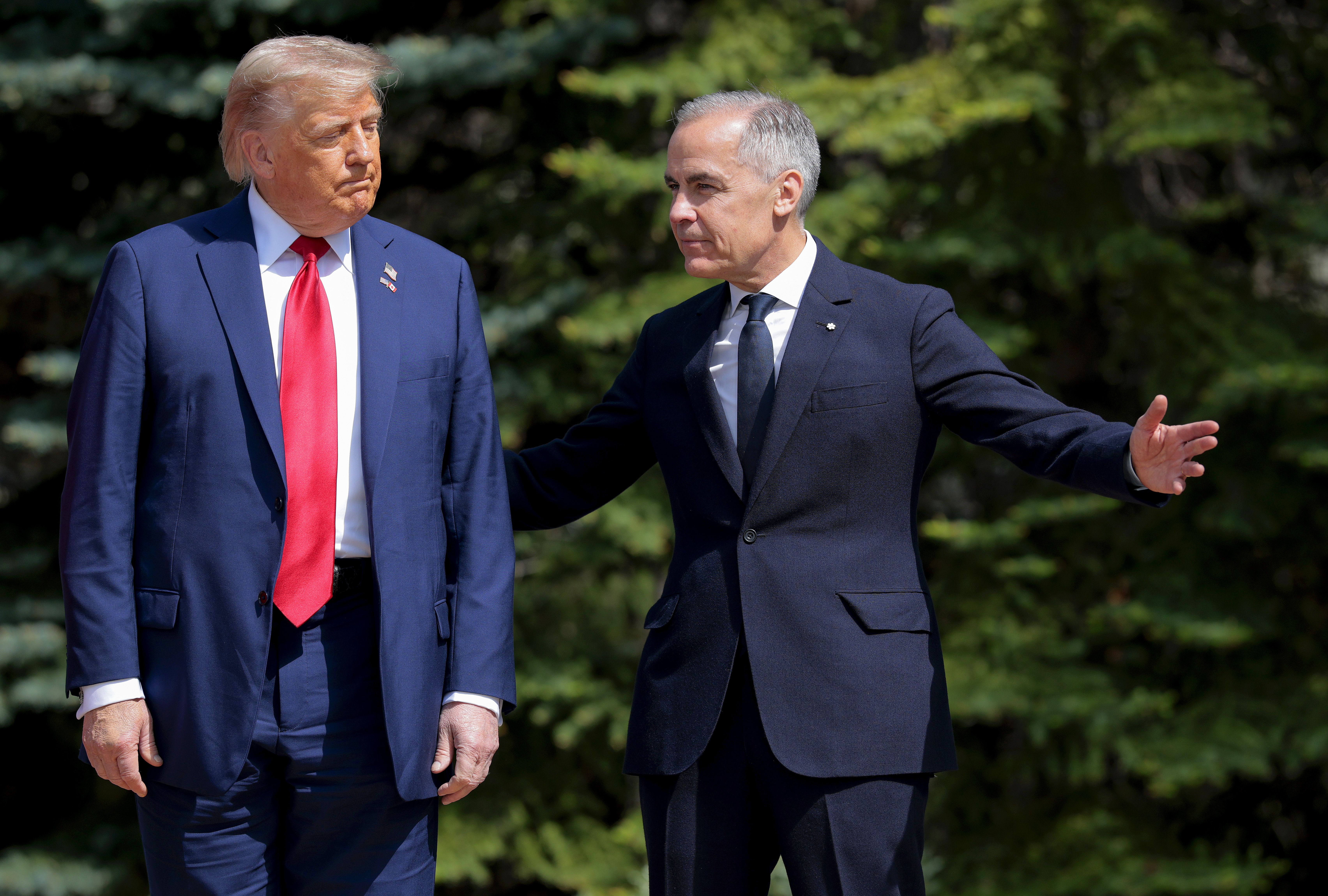 KANANASKIS, ALBERTA - JUNE 16: Canadian Prime Minister Mark Carney (R) greets U.S. President Donald Trump at the official welcome ceremony during the G7 Leaders' Summit on June 16, 2025 in Kananaskis, Alberta. Canada is hosting this year's meeting of the world's seven largest economies.  (Photo by Chip Somodevilla/Getty Images)