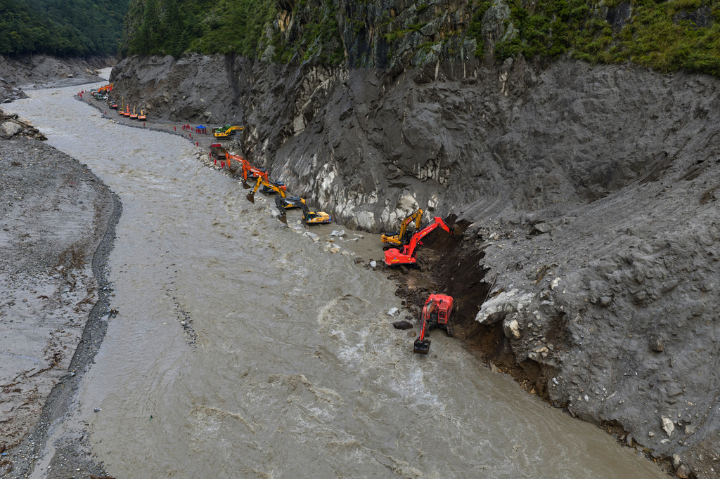 In this photo released by Xinhua News Agency, workers use excavators to move mud from a road damaged by mudslide in Gyirong County, southwestern China's Tibet Autonomous Region on Monday, Aug. 31, 2026. (Jiang Fan/Xinhua via AP)