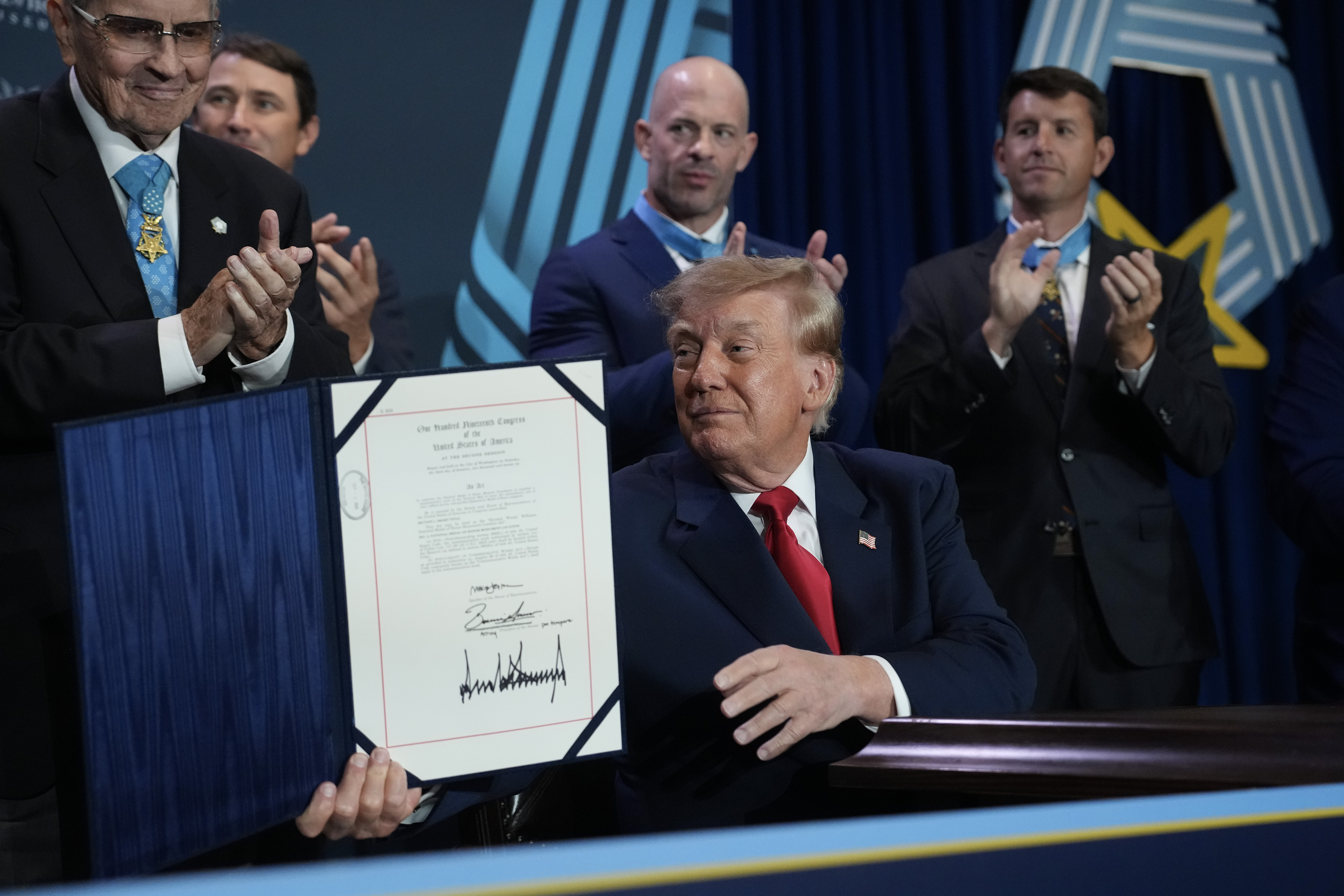 President Donald Trump holds up the Hershel 'Woody' Williams National Medal of Honor Monument Location Act after signing it during an event at the National Medal of Honor Museum on September 10, 2026 in Arlington, Texas (Photo by Andrew Harnik/Getty Images)