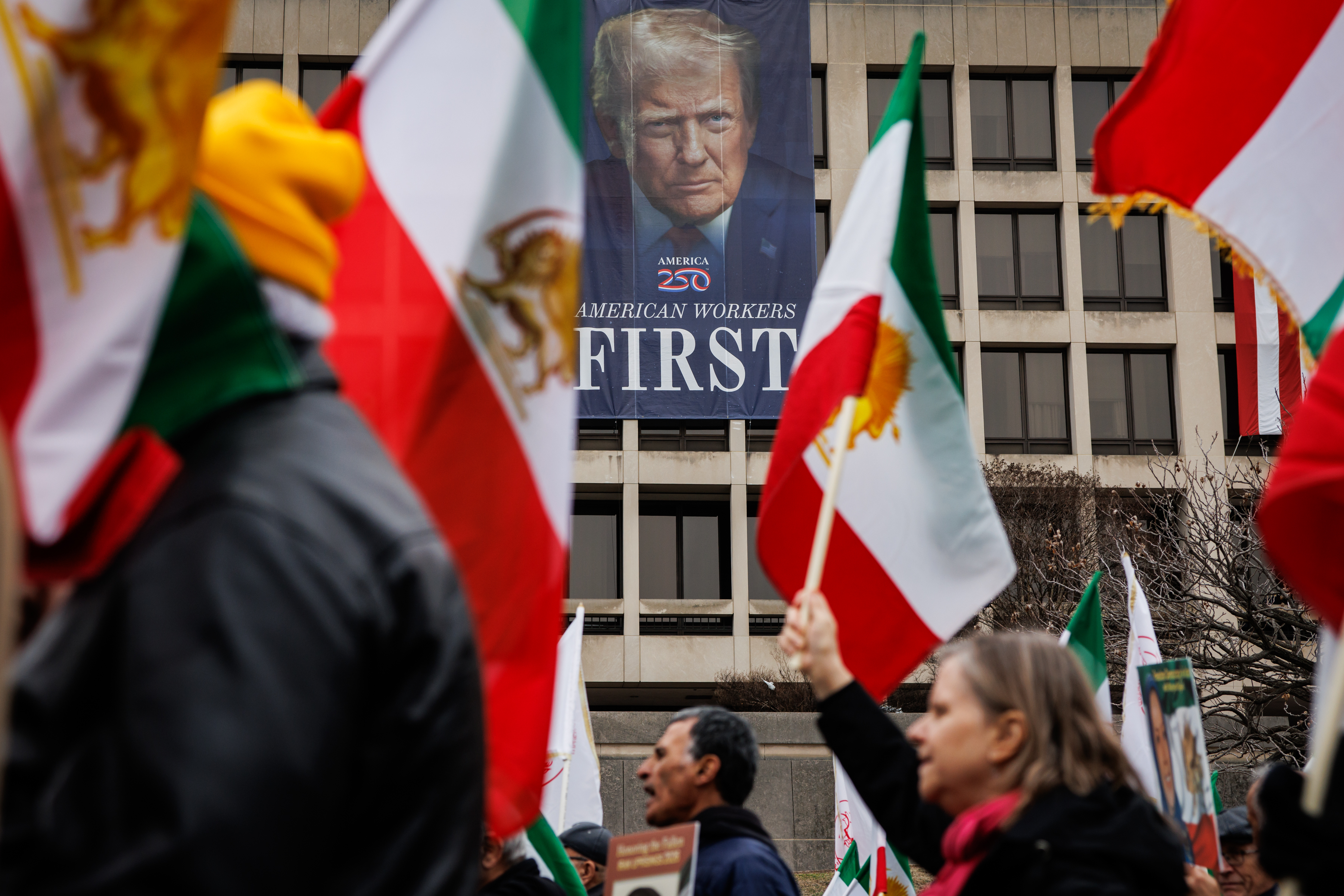 WASHINGTON, DC - MARCH 7: Protestors march past a banner depicting U.S. President Donald Trump on the side of the U.S. Department of Labor during a rally in support of the U.S. and Israeli strikes on Iran on March 7, 2026 in Washington, DC. Iran's Supreme Leader, Ayatollah Ali Khamenei, was confirmed killed after the United States and Israel launched a joint attack on Iran on February 28. Iran retaliated by firing waves of missiles and drones at Israel, and targeting U.S. allies in the region. (Photo by Samuel Corum/Getty Images)