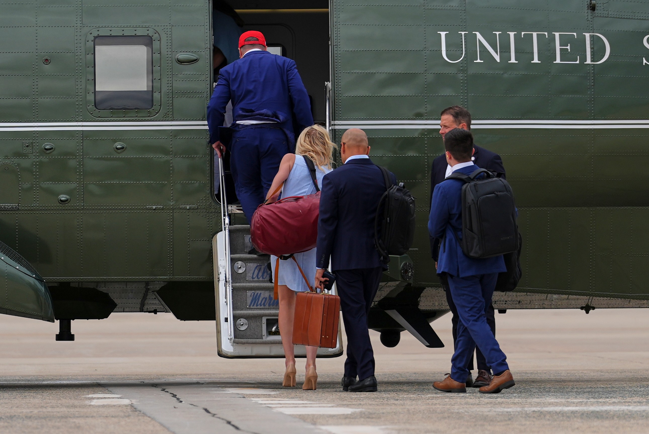 Bill Pulte, acting director of national intelligence, from left, White House aide Natalie Harp and Walt Nauta, personal aide to President Donald Trump, board Marine One, Sunday, Aug. 16, 2026, at Joint Base Andrews, Md. (AP Photo/Julia Demaree Nikhinson)