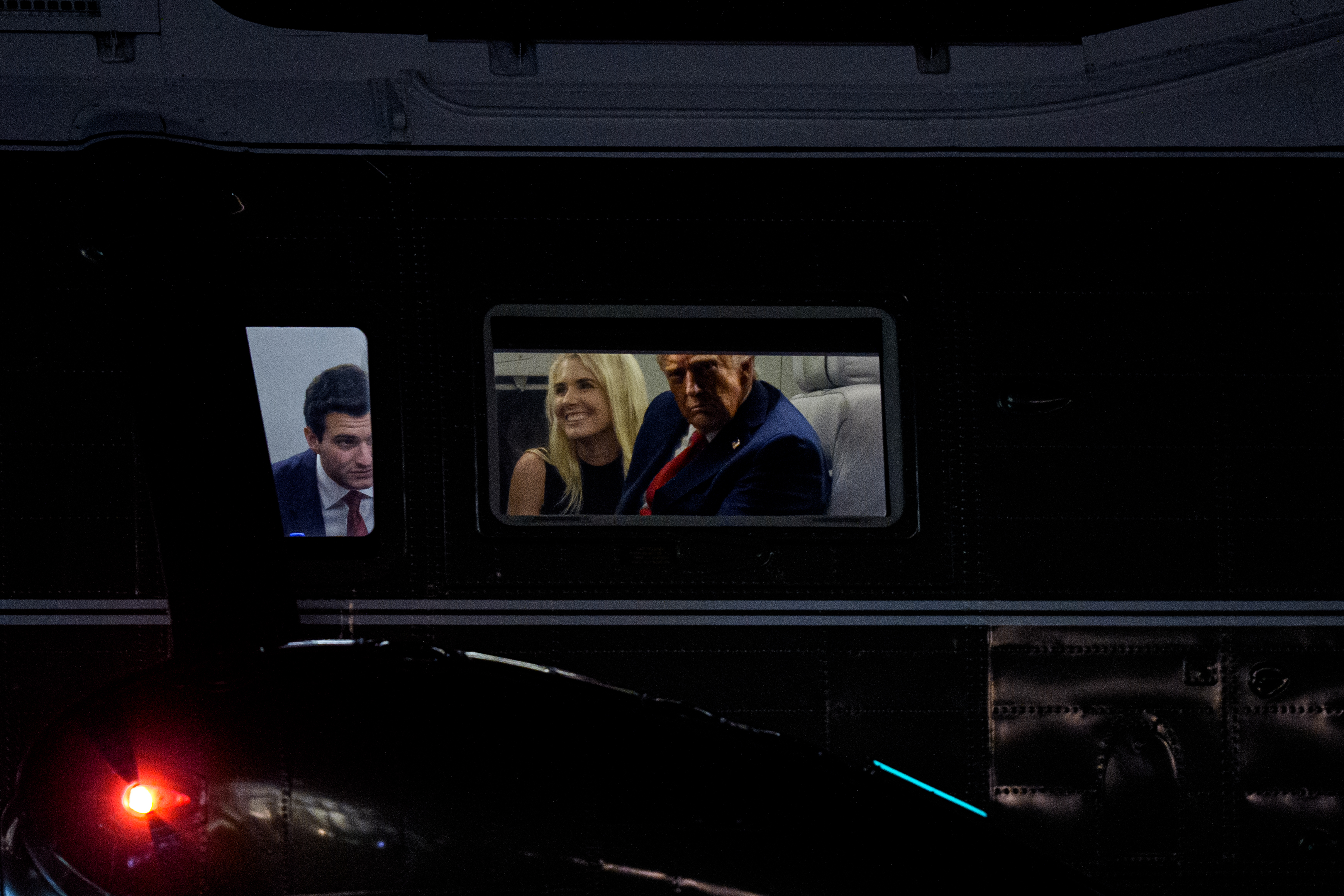 WASHINGTON, DC - SEPTEMBER 18: U.S. President Donald Trump (R), accompanied by Tiffany Trump's husband Michael Boulos (L), and aide Natalie Harp (C), looks out the window of Marine One as it lands on the South Lawn of the White House on September 18, 2025 in Washington, DC. Trump returned following his second UK state visit, with the previous one taking place in 2019 during his first presidential term. (Photo by Andrew Harnik/Getty Images)