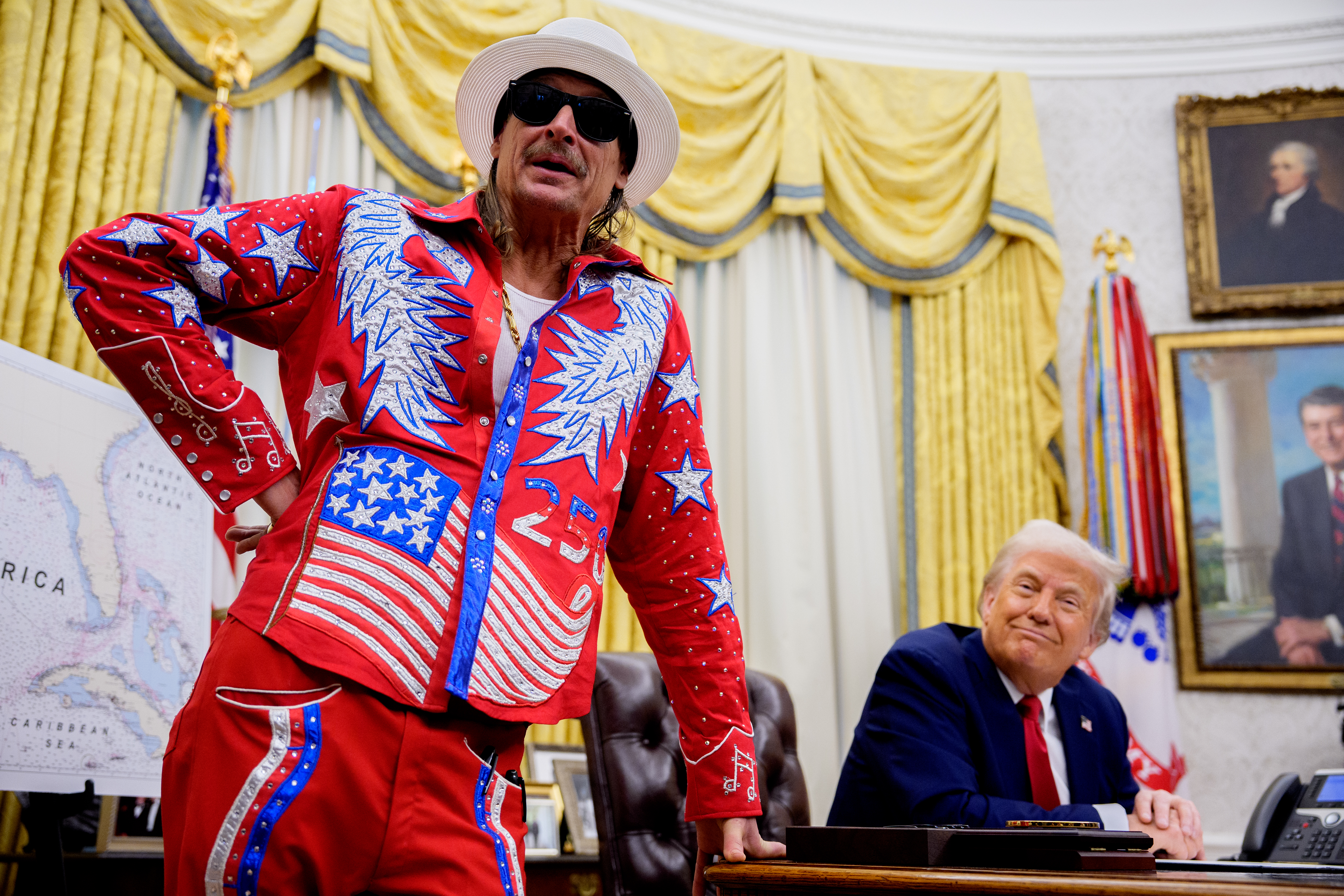 WASHINGTON, DC - MARCH 31: U.S. President Donald Trump listens as entertainer Kid Rock speaks during an executive order signing event in the Oval Office of the White House on March 31, 2025 in Washington, DC. Trump has signed an executive order against ticket scalping and reforming the live entertainment ticket industry. (Photo by Andrew Harnik/Getty Images)