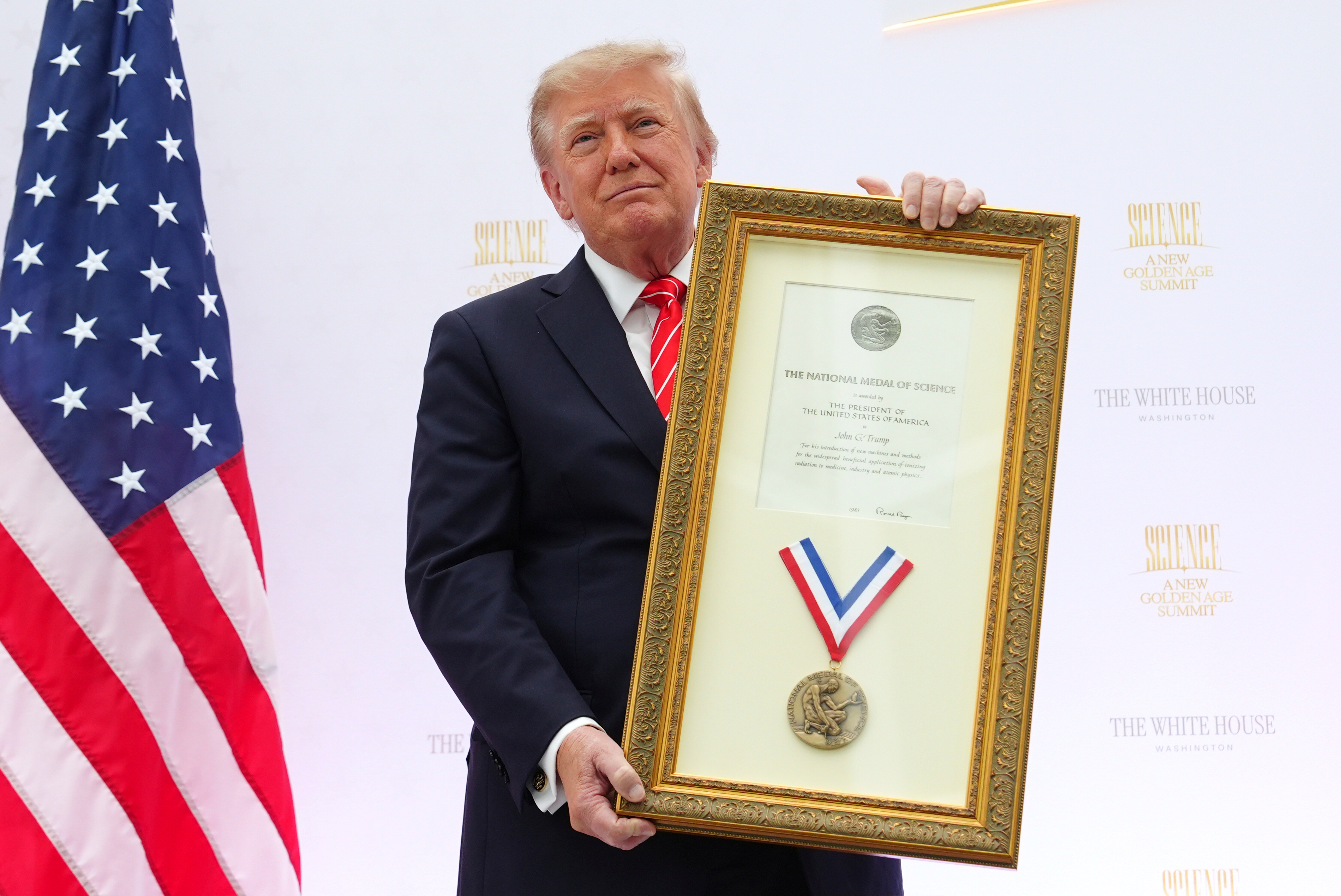 President Donald Trump holds up the National Medal of Science previously honored to his uncle, John G. Trump, during an event at the U.S. Institute of Peace, Thursday, Oct. 8, 2026, in Washington. (AP Photo/Julia Demaree Nikhinson)