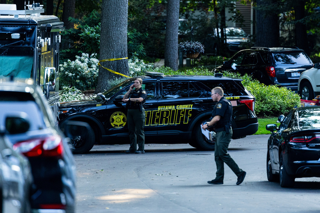 Law enforcement investigate the scene of a fatal house fire on Friday, July 24, 2026, in the in Grand Haven Township, Mich. Ottawa County Sheriff's Office said six children and two adults were found dead in a