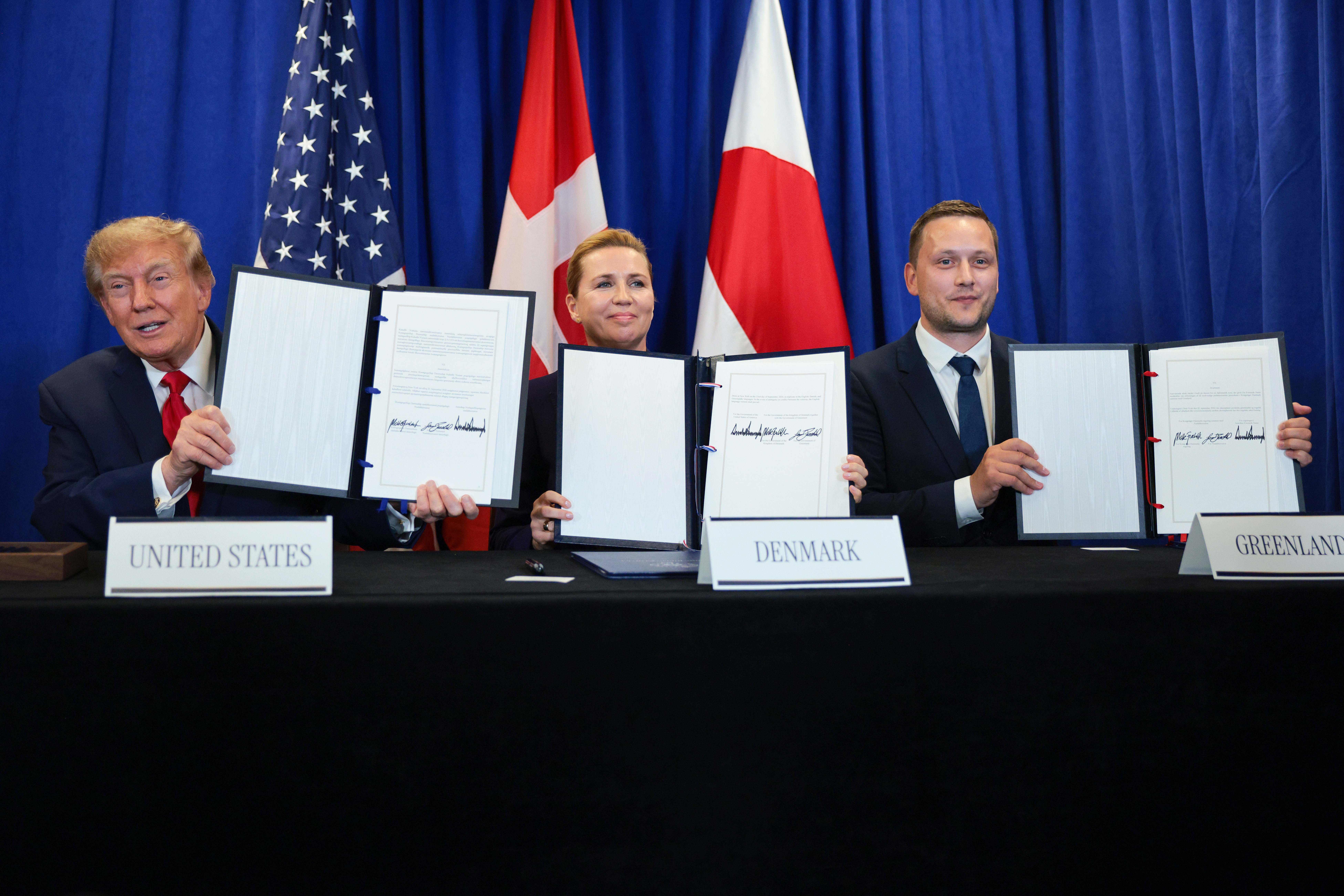 NEW YORK, NEW YORK - SEPTEMBER 22: (L-R) U.S. President Donald Trump, Prime Minister of Denmark Mette Frederiksen and Prime Minister of Greenland Jens-Frederik Nielsen hold up the proclamations during the signing of a security pact between the U.S., Denmark, and Greenland during the 81st session of the United Nations (U.N.) General Assembly at U.N. Headquarters on September 22, 2026 in New York City. World leaders have gathered in New York for the annual session of the United Nations General Assembly, with this year's global issues ranging from the threat of artificial intelligence to the continued wars in Ukraine and Gaza. (Photo by Chip Somodevilla/Getty Images)