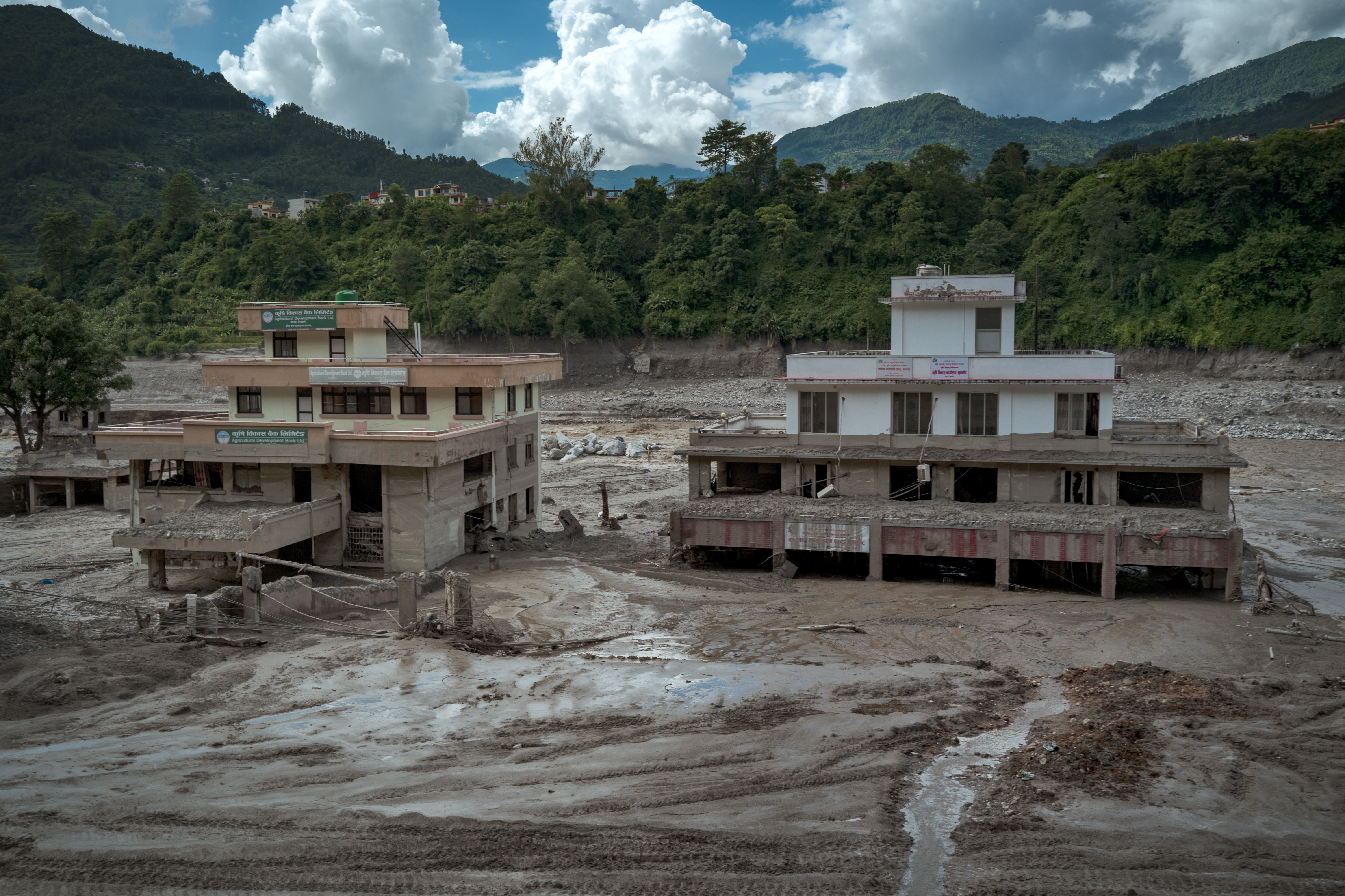 TRISHULI, NEPAL - AUGUST 27: Damaged buildings are seen partially covered in heavy mud following flash floods on August 27, 2026 in Trishuli, Nepal. A sudden flood swept through the Bhote Koshi River basin in northern Rasuwa on August 26, damaging settlements, roads and energy infrastructure as rescue teams searched for residents and foreign travellers reported out of contact. Hundreds were reported missing, as the death toll started to climb. (Photo by Ezra Acayan/Getty Images)