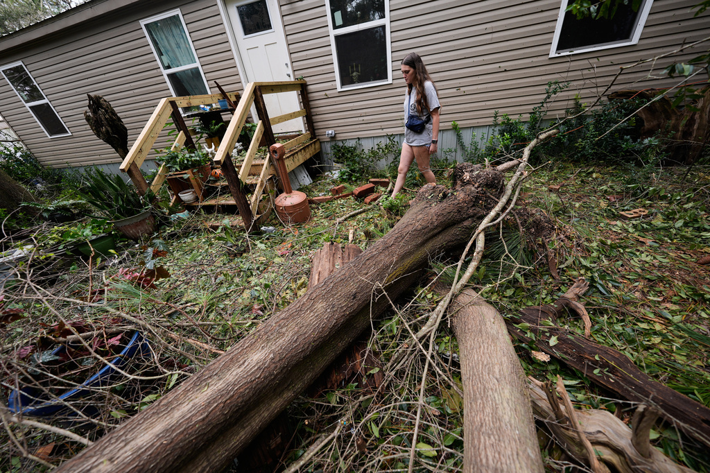 Baleigh Ziglar walks around downed trees in front of her mother's home in the aftermath of Hurricane Isaias in Milton, Fla., Saturday, Oct. 10, 2026. (AP Photo/Gerald Herbert)