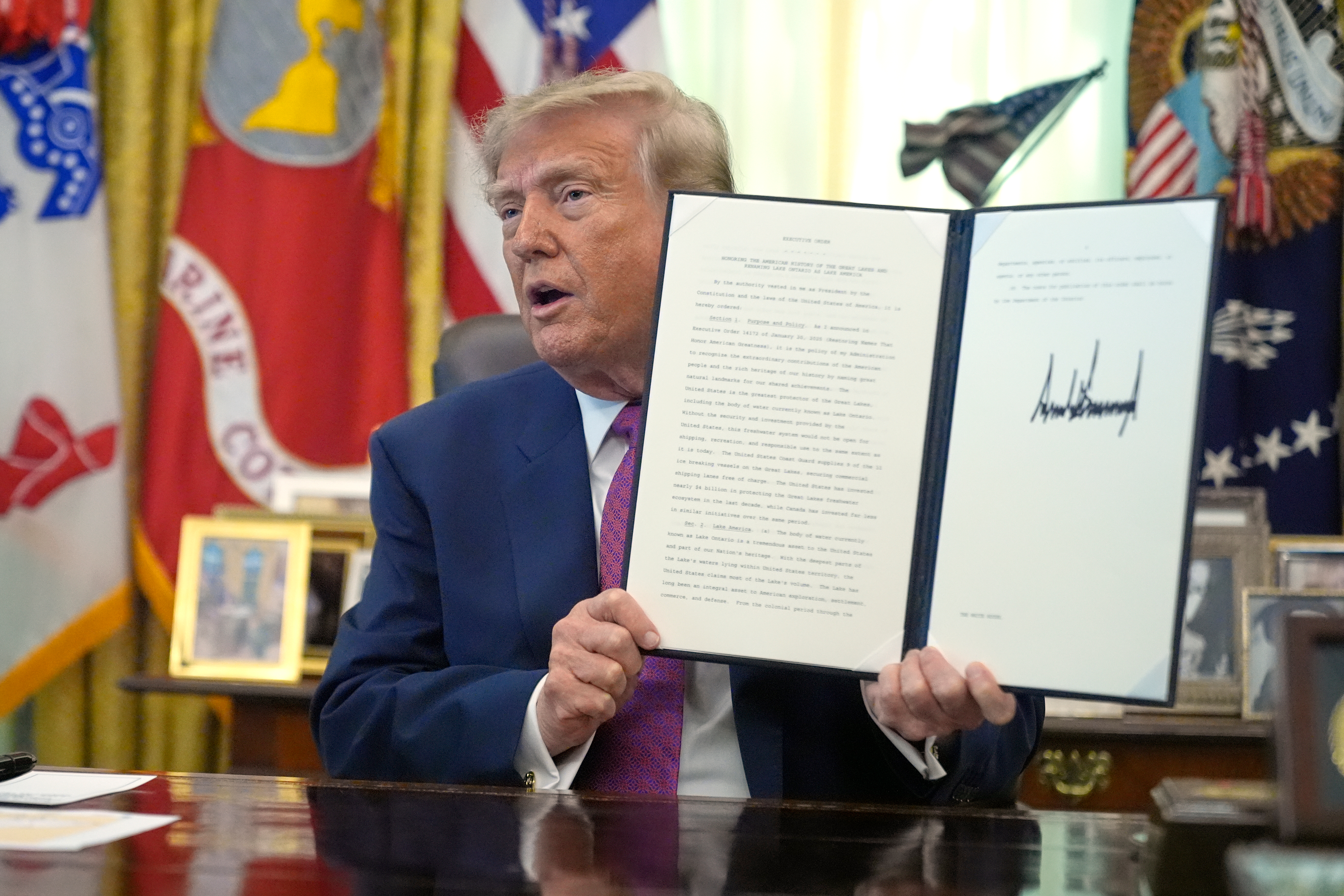 President Donald Trump holds up a signed executive order in the Oval Office of the White House, Thursday, Aug. 27, 2026, in Washington. (AP Photo/Manuel Balce Ceneta)