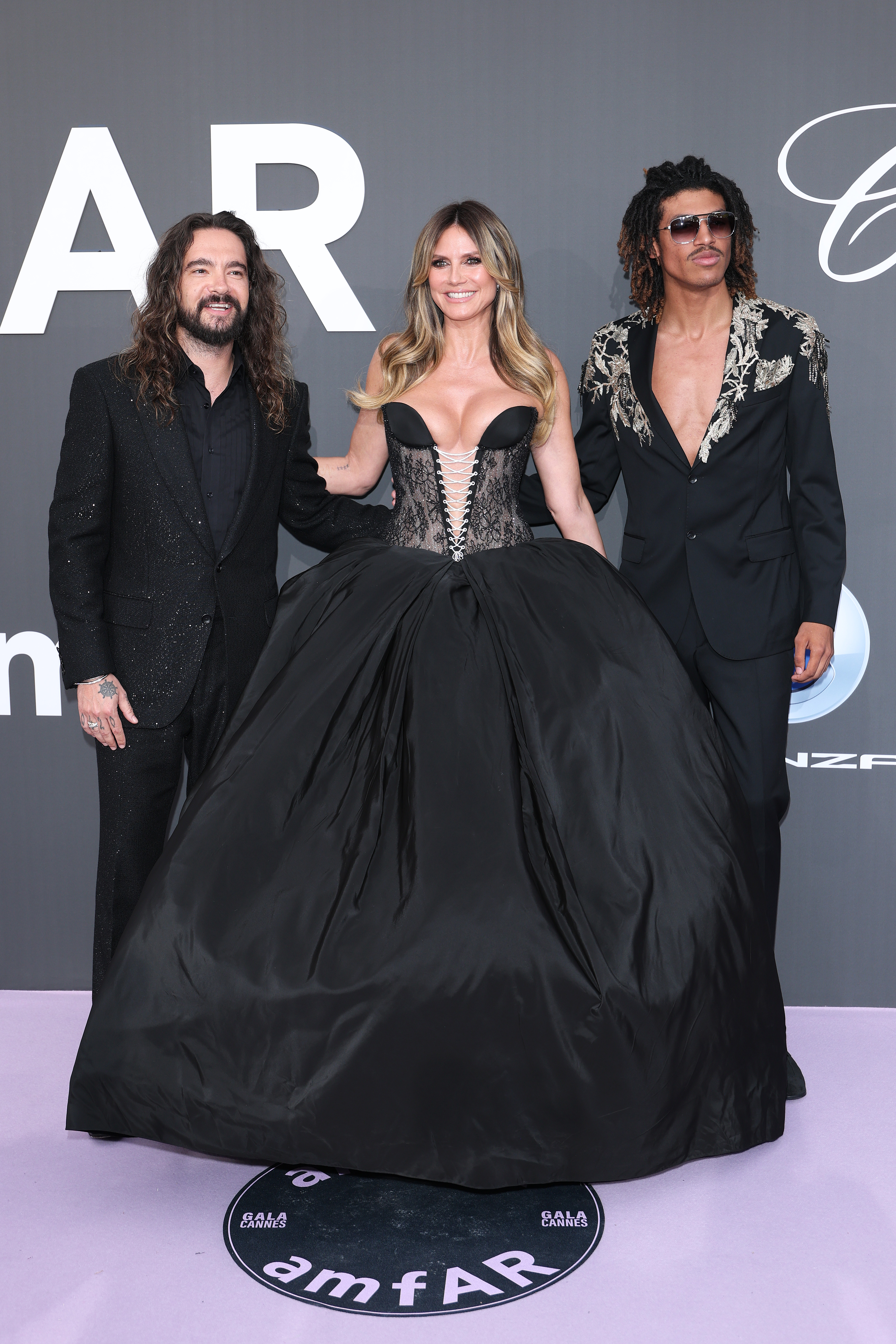 CAP D'ANTIBES, FRANCE - MAY 21: (L-R) Tom Kaulitz, Heidi Klum and Henry Samuel attend the amfAR Gala Cannes 2026 presented by Chopard at Hotel du Cap-Eden-Roc on May 21, 2026 in Cap d'Antibes, France. (Photo by Daniele Venturelli/WireImage)