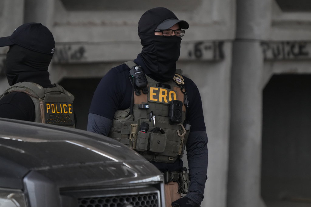 An Immigration and Customs Enforcement officer walks the scene where a man was shot in his vehicle by an ICE officer, Sunday, Sept. 20, 2026, in Austin, Texas. (Aaron E. Martinez /Austin American-Statesman via AP)