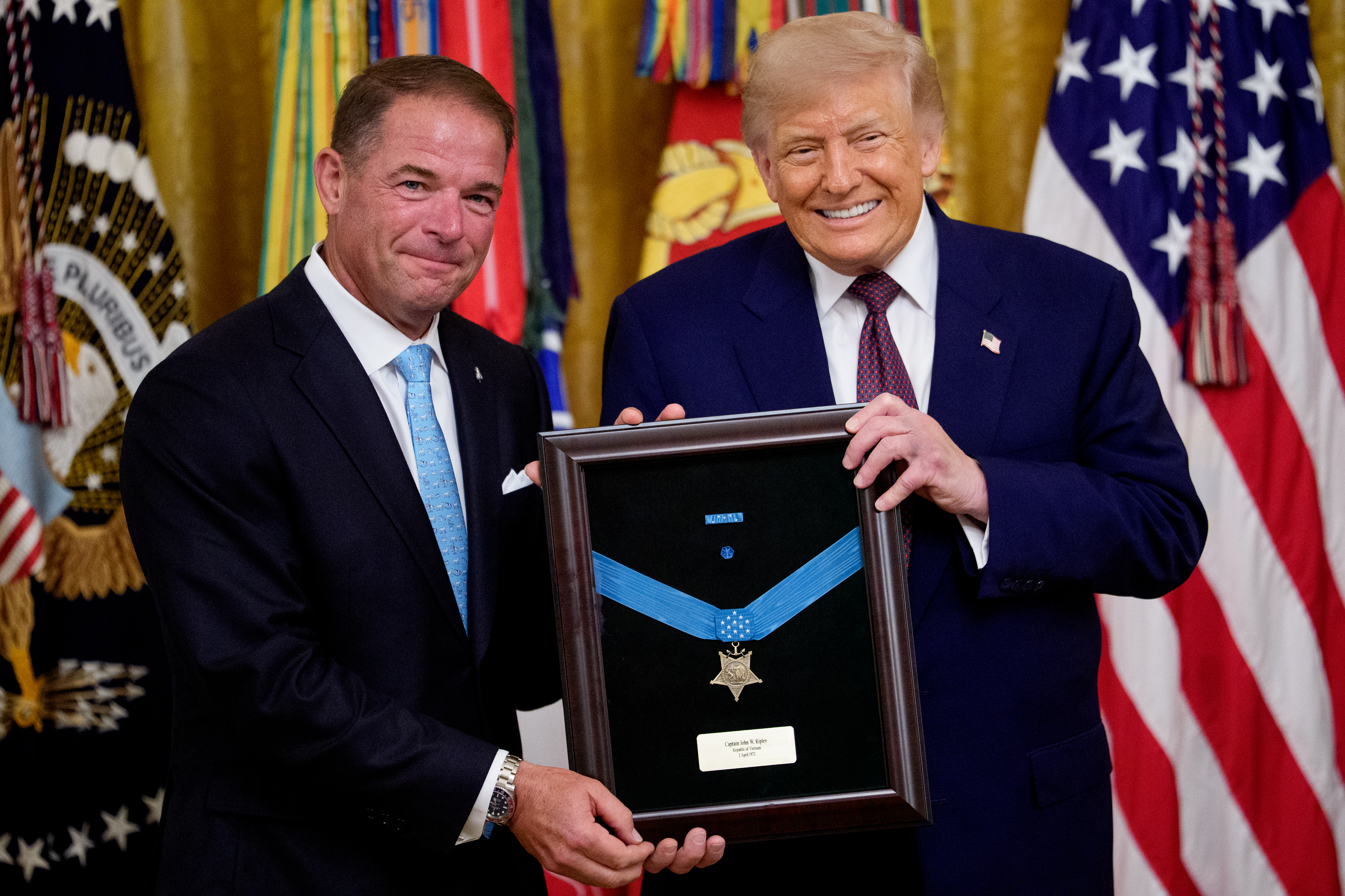 WASHINGTON, DC - JUNE 18: U.S. President Donald Trump presents the Medal of Honor, awarded posthumously to Marine Col. John W. Ripley, to Ripley's son Tom Ripley during a ceremony in the East Room of the White House on June 18, 2026, in Washington, DC. In addition to Ripley, Trump awarded the Medal of Honor to retired Army Maj. Major Nicholas Dockery and to James Capers Jr., an 88-year-old Vietnam veteran who saved the lives of multiple Marines under his command during a 1967 battle at Phu Loc, all while suffering from several gunshot wounds.  (Photo by Andrew Harnik/Getty Images)