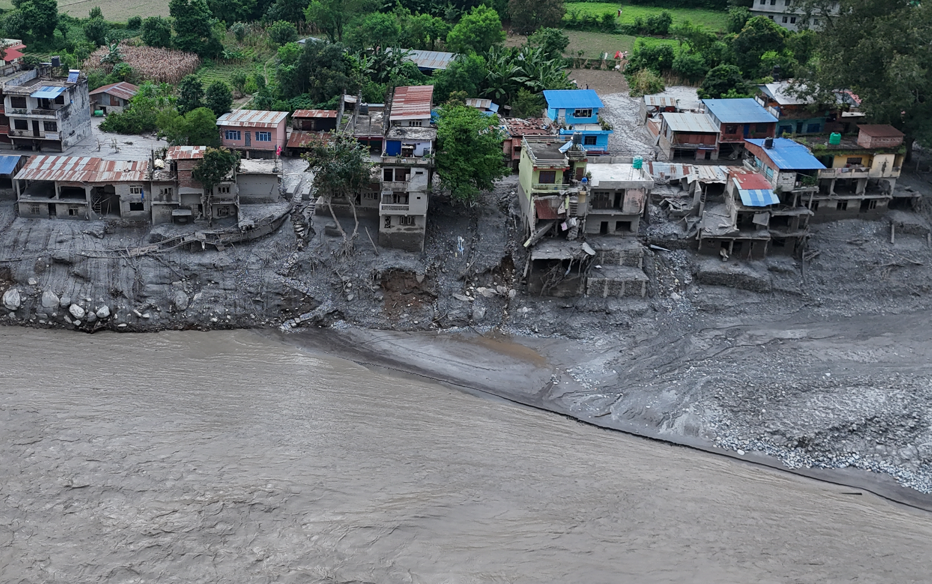 NUWAKOT, NEPAL - AUGUST 28: An Aerial view shows debris and mud covering settlements following flash floods on August 28, 2026 in DevGhat village, Nepal. Authorities said the flash floods were triggered after a mass of ice, mud and rock collapsed into a Himalayan river near the Nepal-China border, leaving hundreds dead or missing and causing widespread damage in affected districts. Authorities continued the gruelling search for victims, many buried under metres of mud, as both China and Nepal issued fresh flooding alerts. (Photo by Ritesh Shukla/Getty Images)
