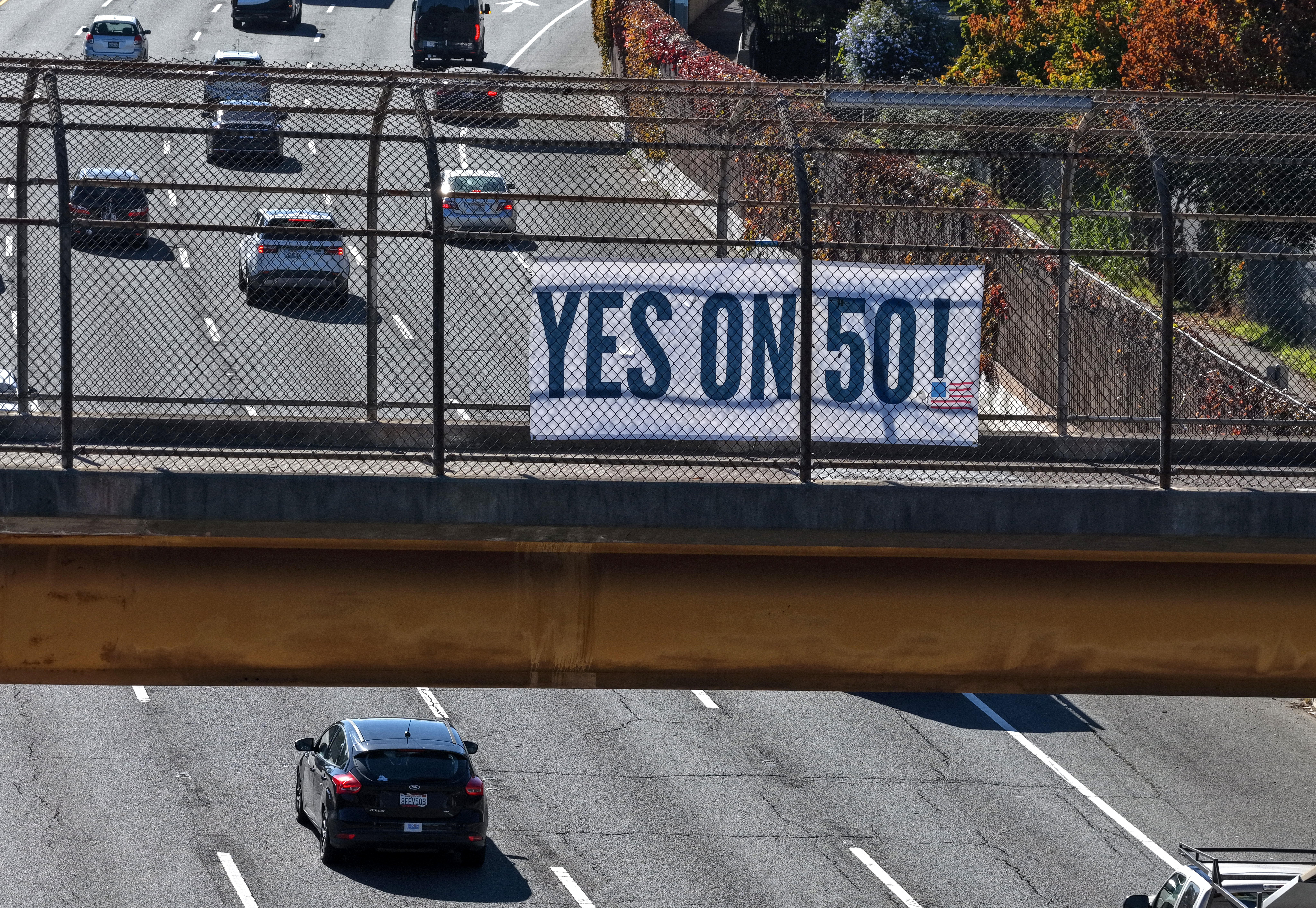 SAN RAFAEL, CALIFORNIA - NOVEMBER 03: In an aerial view, a Yes on 50 sign is posted on a walkway over Highway 101 on November 03, 2025 in San Rafael, California. California voters are deciding whether to approve Proposition 50, a measure that would replace the state’s current congressional district map with new, legislature-drawn lines from 2026 through 2030. The proposition was put forward as a response to Republican-controlled states redrawing their own maps to create an electoral advantage in the 2026 midterms. (Photo by Justin Sullivan/Getty Images)