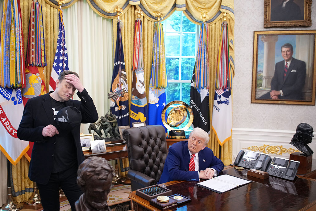 WASHINGTON, DC - MAY 30: Tesla CEO Elon Musk removes his hat as he listens to a question from a reporter alongside U.S. President Donald Trump in the Oval Office of the White House on May 30, 2025 in Washington, DC. Musk, who served as an adviser to Trump and led the Department of Government Efficiency, announced he would leave his role in the Trump administration to refocus on his businesses.  (Photo by Kevin Dietsch/Getty Images)