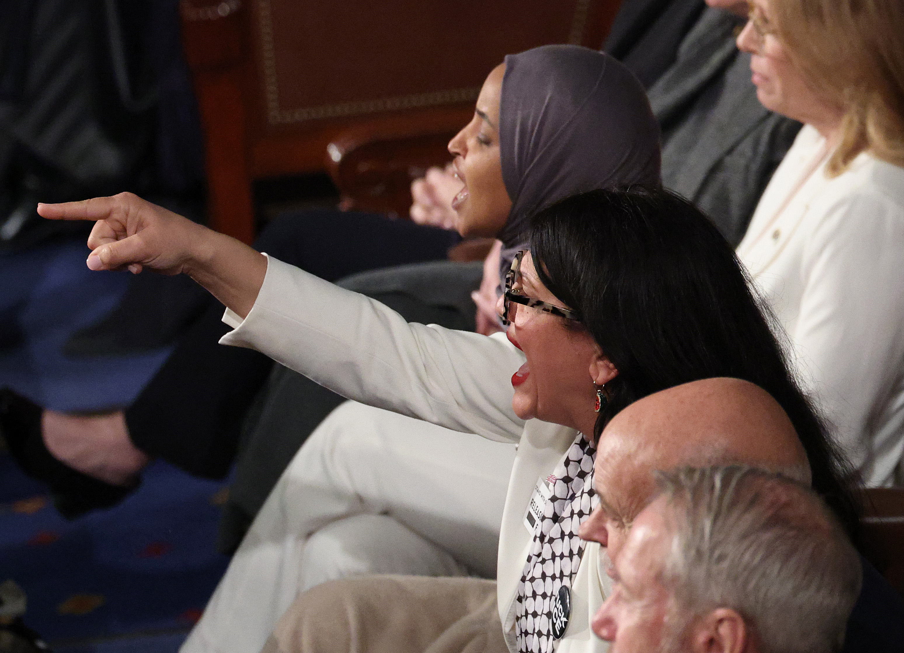 WASHINGTON, DC - FEBRUARY 24: Rep. Rashida Tlaib (D-MI) R) and Rep. Ilhan Omar (D-MI) shout during U.S. President Donald Trump's State of the Union address during a Joint Session of Congress at the U.S. Capitol on February 24, 2026, in Washington, DC. Trump delivered his address days after the Supreme Court struck down the administration's tariff strategy and amid a U.S. military buildup in the Persian Gulf threatening Iran. (Photo by Win McNamee/Getty Images)