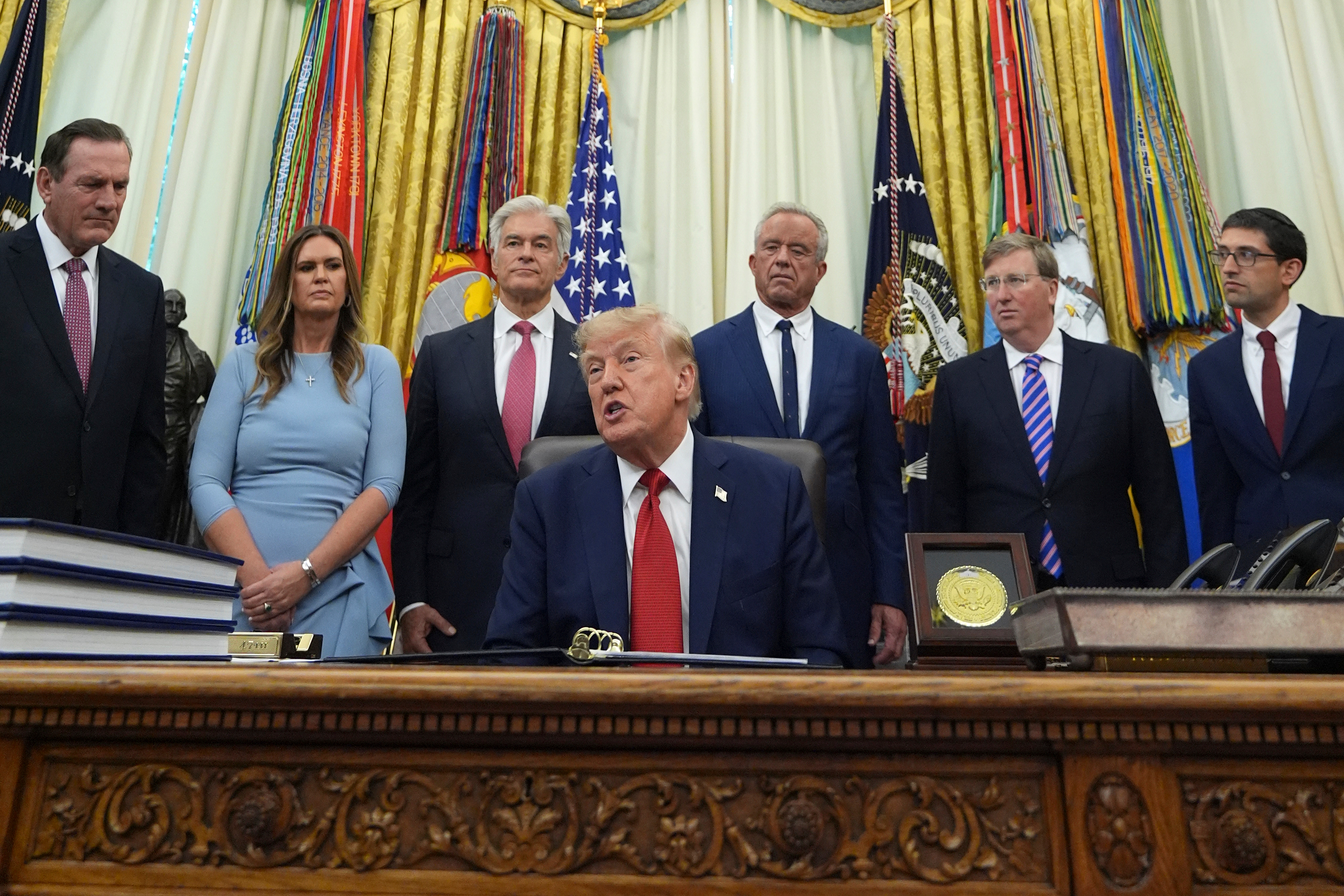 President Donald Trump speaks as South Dakota Gov. Larry Rhoden, from left, Arkansas Gov. Sarah Huckabee Sanders, Mehmet Oz, administrator of the Centers for Medicare & Medicaid Services, Health and Human Services Secretary Robert F. Kennedy Jr., Mississippi Gov. Tate Reeves and Abe Sutton, director of the Center for Medicare and Medicaid Innovation, listen during an event about healthcare in the Oval Office of the White House, Friday Sept. 18, 2026, in Washington. (AP Photo/Jacquelyn Martin)