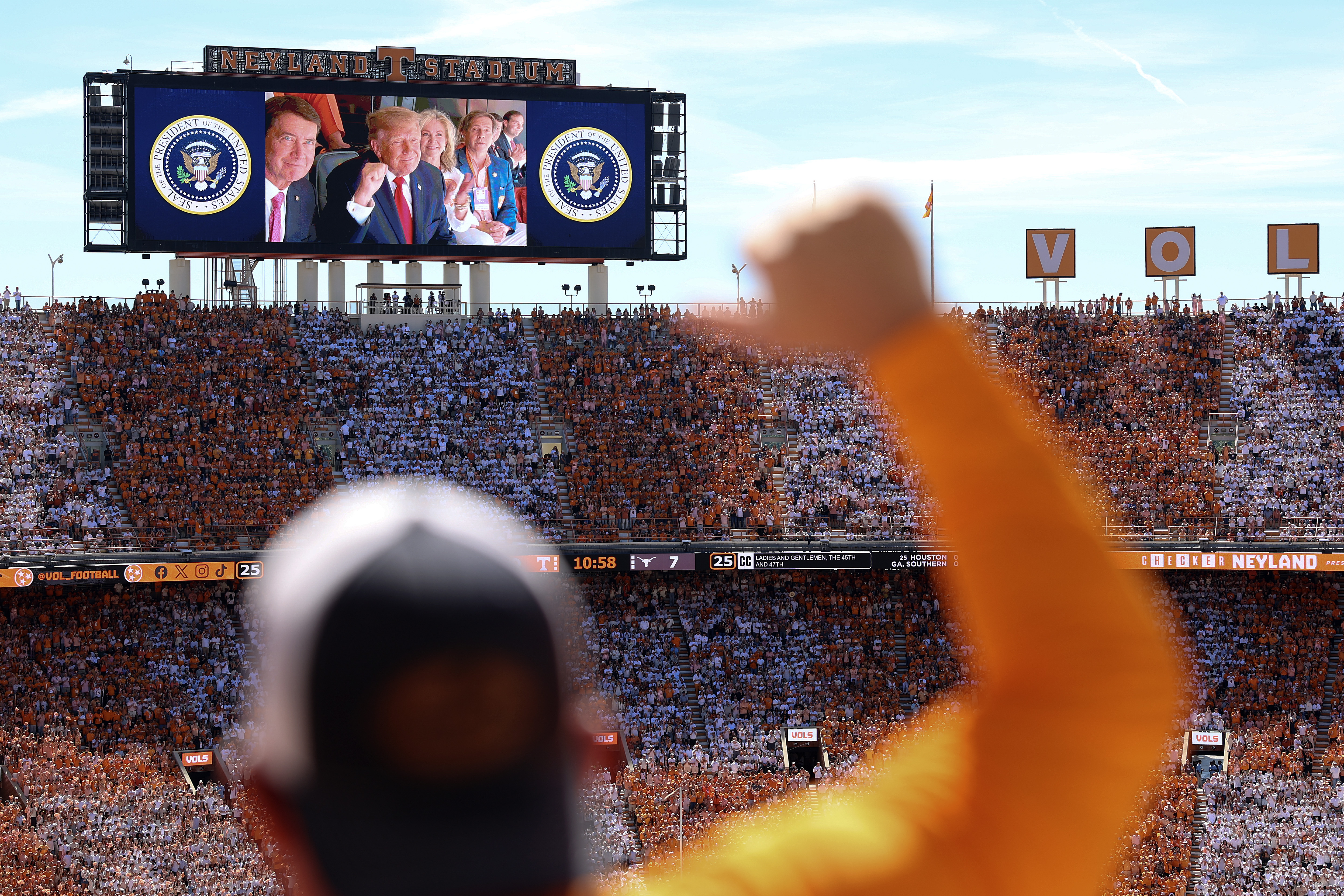KNOXVILLE, TENNESSEE - SEPTEMBER 26: U.S. President Donald Trump, Sen. Bill Hagerty (R-TN) (L) and Sen. Marsha Blackburn (R-TN) appear on a video screen while attending the Texas-Tennessee football game at Neyland Stadium on September 26, 2026 in Knoxville, Tennessee. Trump, who has attended more college football games than any recent sitting president, attended the game between the No. 1 Longhorns and the No. 14. Volunteers, one of the biggest matchups in the country this weekend. (Photo by Tom Brenner/Getty Images)