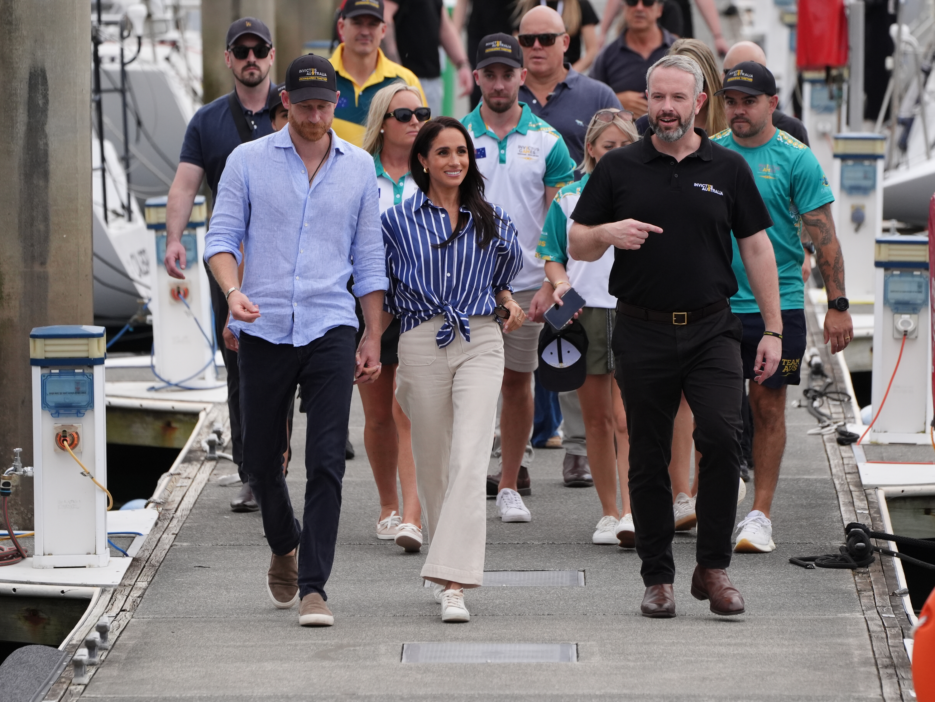 SYDNEY, AUSTRALIA - APRIL 17:  Prince Harry, Duke of Sussex and Meghan, Duchess of Sussex walk and talk with Michael Hartung, CEO of Invictus Australia after taking part in a sailing event with Invictus members in Sydney Harbour, on day four of the royal trip on April 17, 2026 in Sydney, Australia. The royal couple are on a four-day visit to Australia, with engagements across Melbourne, Canberra and Sydney.  (Photo by Jonathan Brady-Pool/Getty Images)