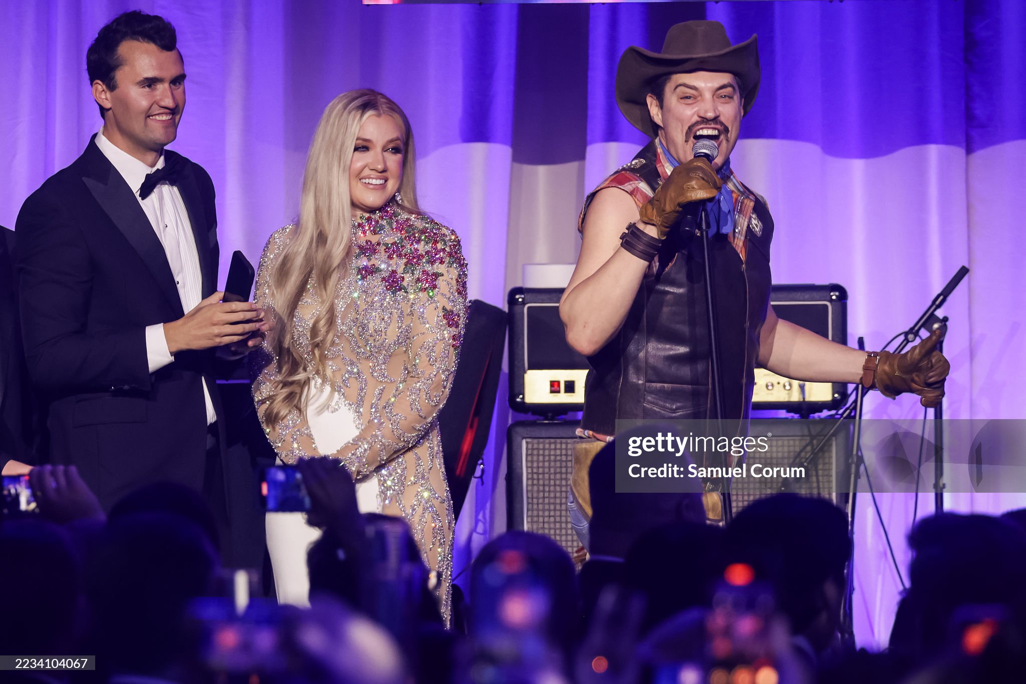 WASHINGTON, DC - JANUARY 19: Charlie Kirk (L) and and his wife Erika Lane Frantzve (C) watch as The Village People perform on stage during the Turning Point USA Inaugural-Eve Ball at the Salamander Hotel on January 19, 2025 in Washington, DC. (Photo by Samuel Corum/Getty Images)