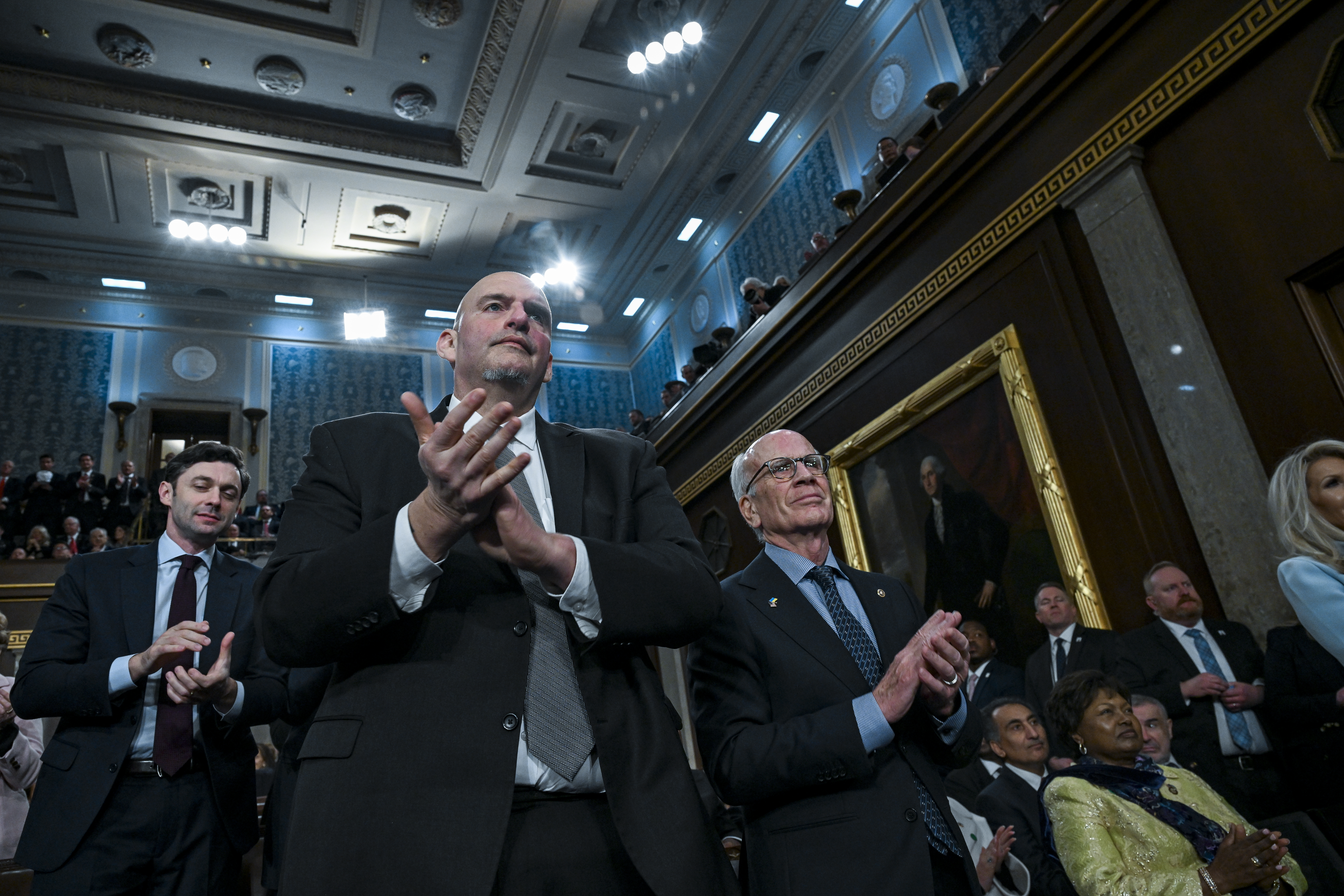 WASHINGTON, DC - FEBRUARY 24: Senator John Fetterman (D-PA) and Senator Peter Welch (D-VT) applaud as U.S. President Donald Trump delivers the State of the Union address during a joint session of Congress in the House Chamber at the Capitol on February 24, 2026 in Washington, DC. Trump delivered his address days after the Supreme Court struck down the administration's tariff strategy, and amid a U.S. military buildup in the Persian Gulf threatening Iran. (Photo by Kenny Holston-Pool/Getty Images)