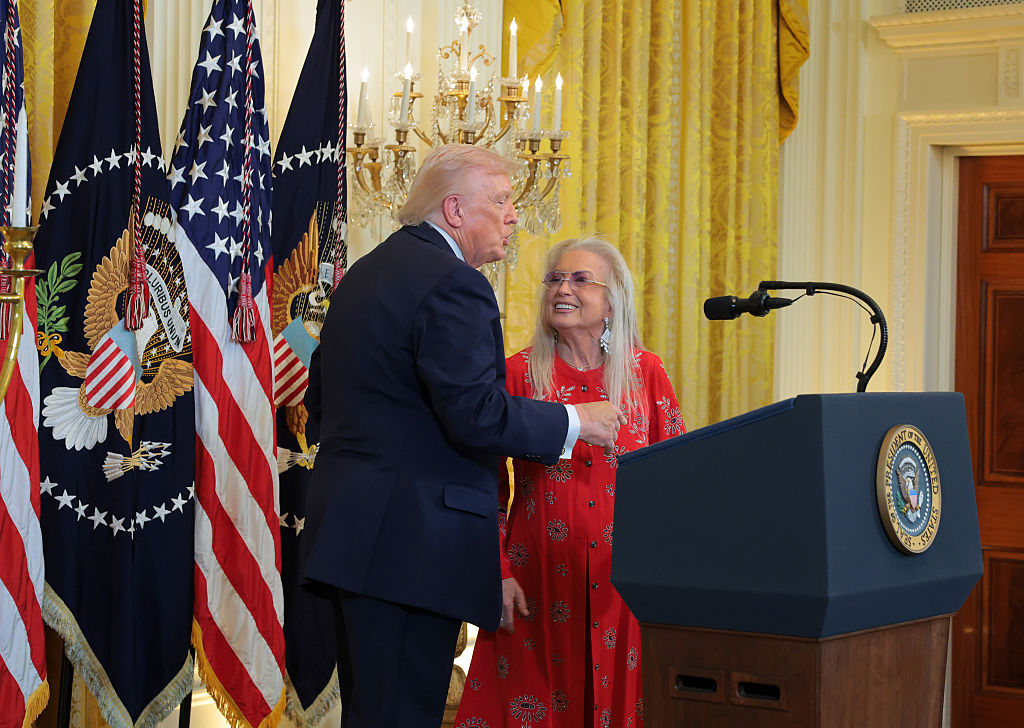 WASHINGTON, DC - DECEMBER 16: U.S. President Donald Trump (L) and Miriam Adelson (R) speak during a Hanukkah Reception in the East Room of the White House on December 16, 2025 in Washington, DC. Trump hosted attendees to celebrate the holiday and the lighting of the menorah on the third night of Hanukkah. (Photo by Anna Moneymaker/Getty Images)