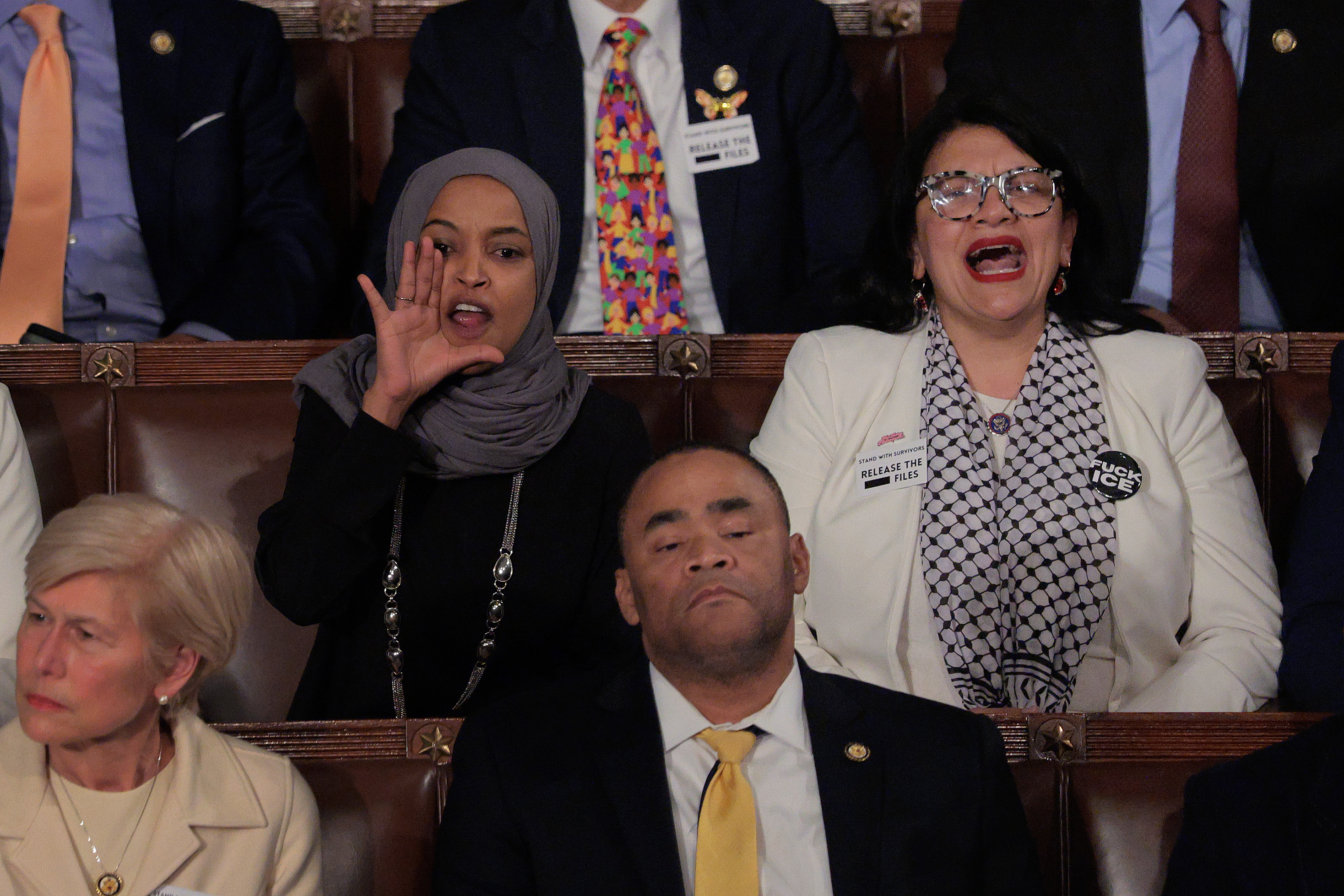 WASHINGTON, DC - FEBRUARY 24: Rep. Ilhan Omar (D-MN) (L) and Rep. Rashida Tlaib (D-MI) shout at U.S. President Donald Trump as he delivers his State of the Union address during a Joint Session of Congress at the U.S. Capitol on February 24, 2026, in Washington, DC. Trump delivered his address days after the Supreme Court struck down the administration's tariff strategy and amid a U.S. military buildup in the Persian Gulf threatening Iran. (Photo by Chip Somodevilla/Getty Images)