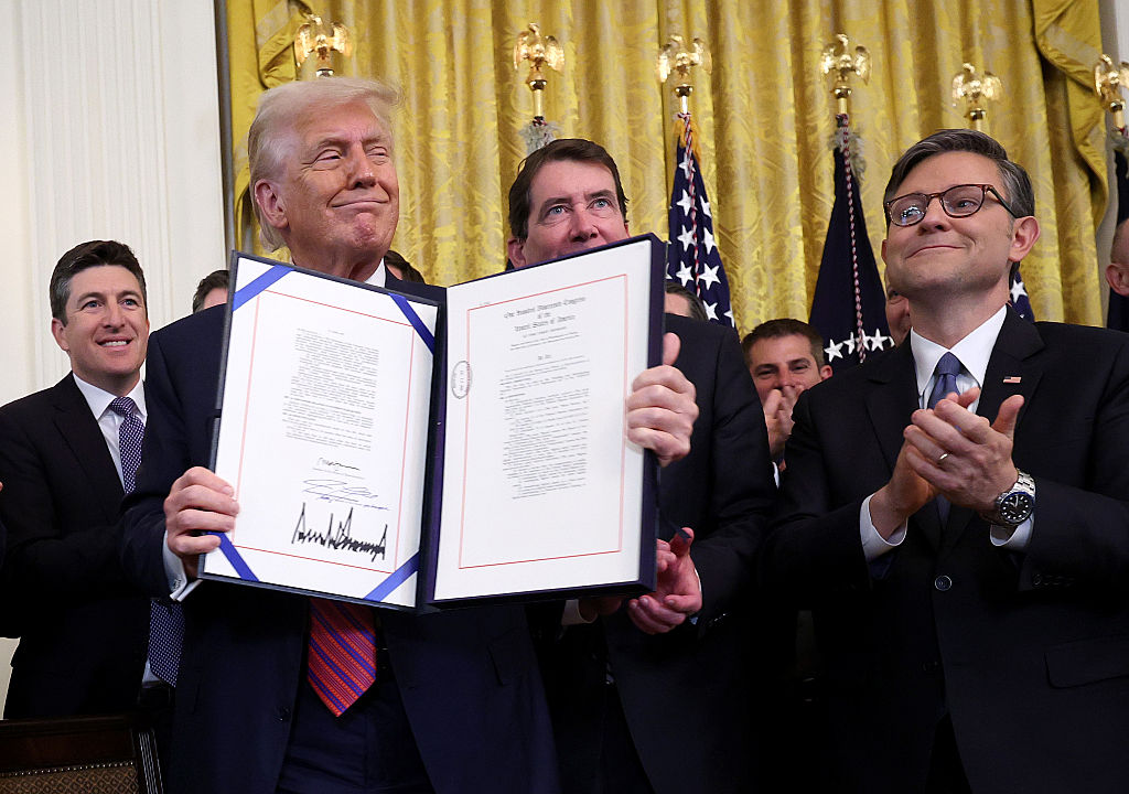 WASHINGTON, DC - JULY 18: U.S. President Donald Trump holds up the “GENIUS Act” alongside Speaker of the House Mike Johnson (R-LA) after signing the bill into law during a ceremony in the East Room of the White House July 18, 2025 in Washington, DC.  The act, formally known as the Guiding and Establishing National Innovation for U.S. Stablecoins Act, was passed this week by the U.S. Congress. (Photo by Win McNamee/Getty Images)