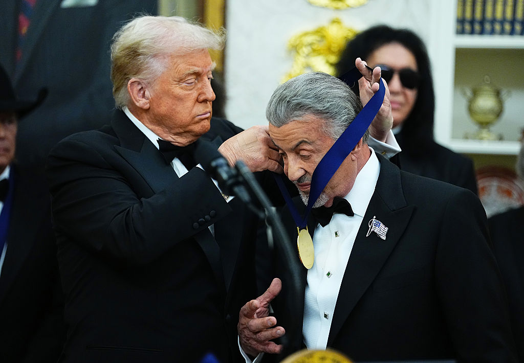 WASHINGTON, DC - DECEMBER 06: U.S. President Donald Trump (L) presents actor Sylvester Stallone (R) with a medal for the 2025 Kennedy Center Honorees during a medal presentation in the Oval Office of the White House on December 06, 2025 in Washington, DC. The 2025 Kennedy Center honorees are Sylvester Stallone, George Strait, the rock band KISS, Gloria Gaynor, and Michael Crawford. (Photo by Aaron Schwartz/Getty Images)