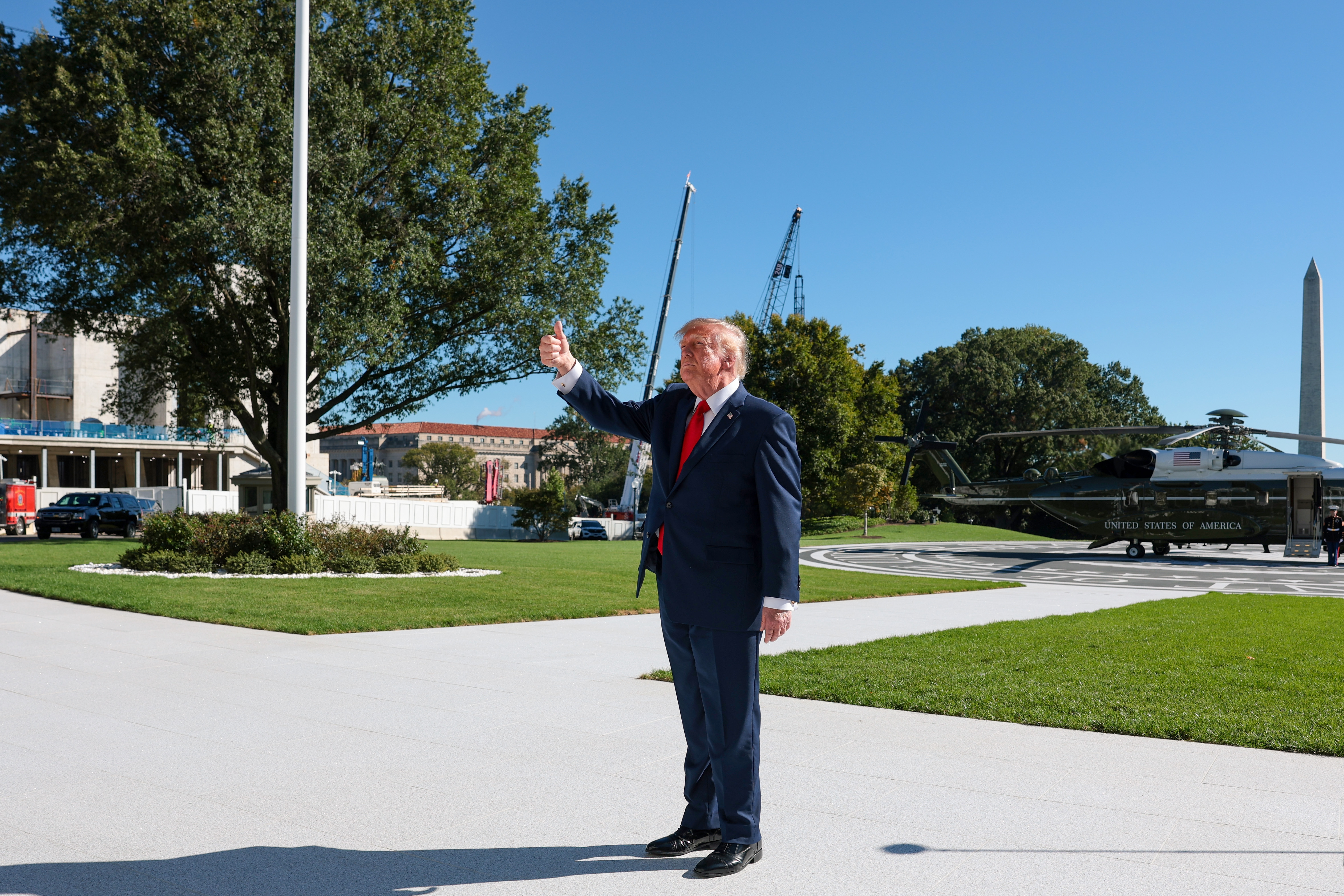 WASHINGTON, DC - OCTOBER 06: U.S. President Donald Trump gives the thumbs up to Gold Star families as they watch from the Truman Balcony as he departs on the South Lawn of the White House on October 06, 2026 in Washington, DC. President Trump is traveling to Maryland to deliver remarks at the Tradepoint Atlantic industrial center in the Port of Baltimore. (Photo by Anna Moneymaker/Getty Images)