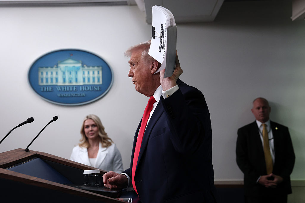 WASHINGTON, DC - JANUARY 20: U.S. President Donald Trump displays a stack of binders as he speaks to the media during a press briefing in the James S. Brady Press Briefing Room of the White House on January 20, 2026 in Washington, DC. White House Press Secretary Karoline Leavitt was joined by President Trump days after the president threatened a 10% import tax on goods from eight European countries that have rallied around Denmark amid Trump's calls for the U.S. to take control of Greenland, a semi-autonomous Danish territory. (Photo by Win McNamee/Getty Images)