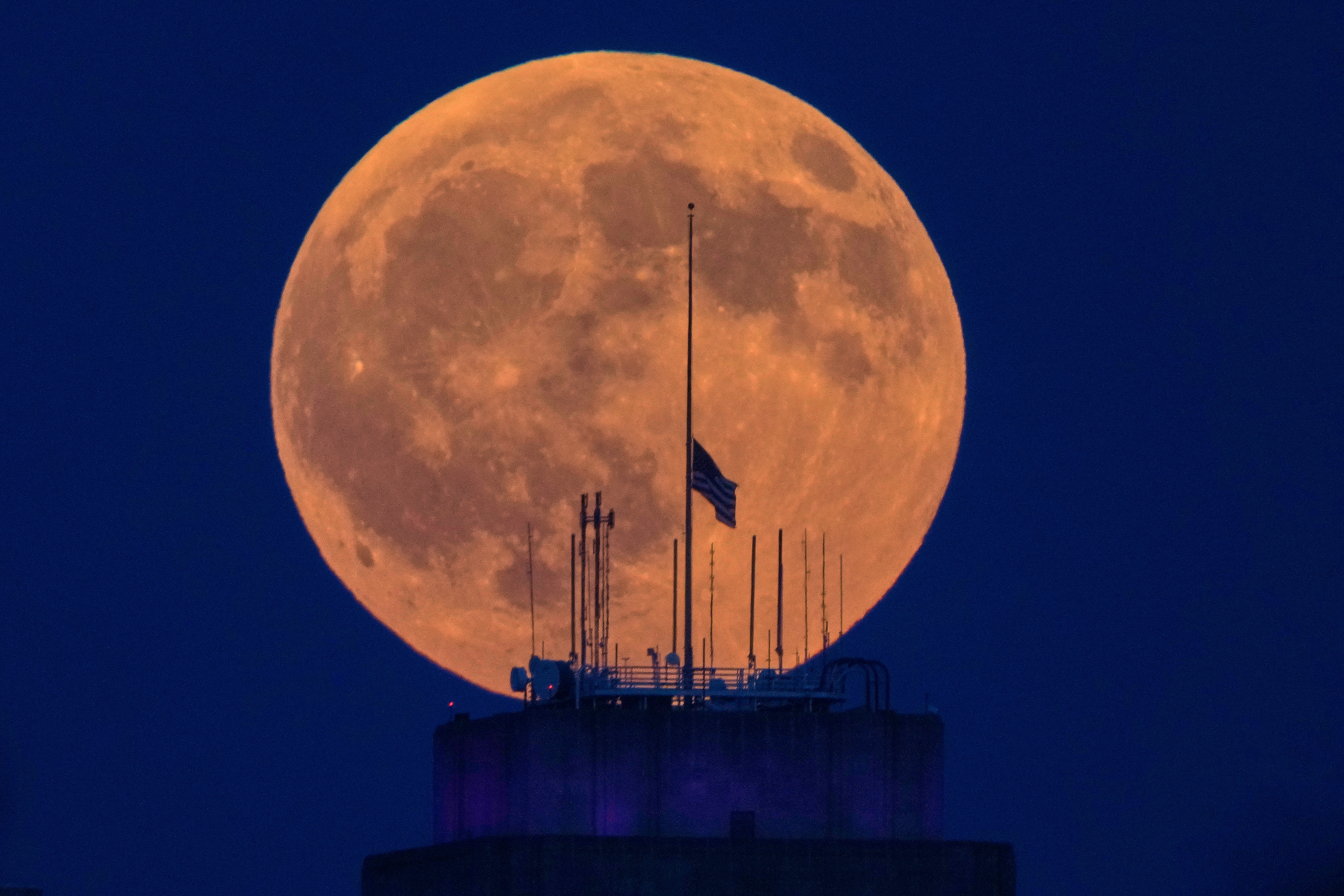 The full moon rises beyond the city hall in downtown Kansas City, Mo. before a lunar eclipse Thursday, Aug. 27, 2026. (AP Photo/Charlie Riedel)