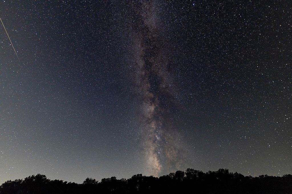 A meteor streaks across the sky during the Perseid meteor shower peak at Pedernales Falls State Park on August 13, 2026 in Johnson City, Texas. (Image Source: Rick Kern/Getty Images)