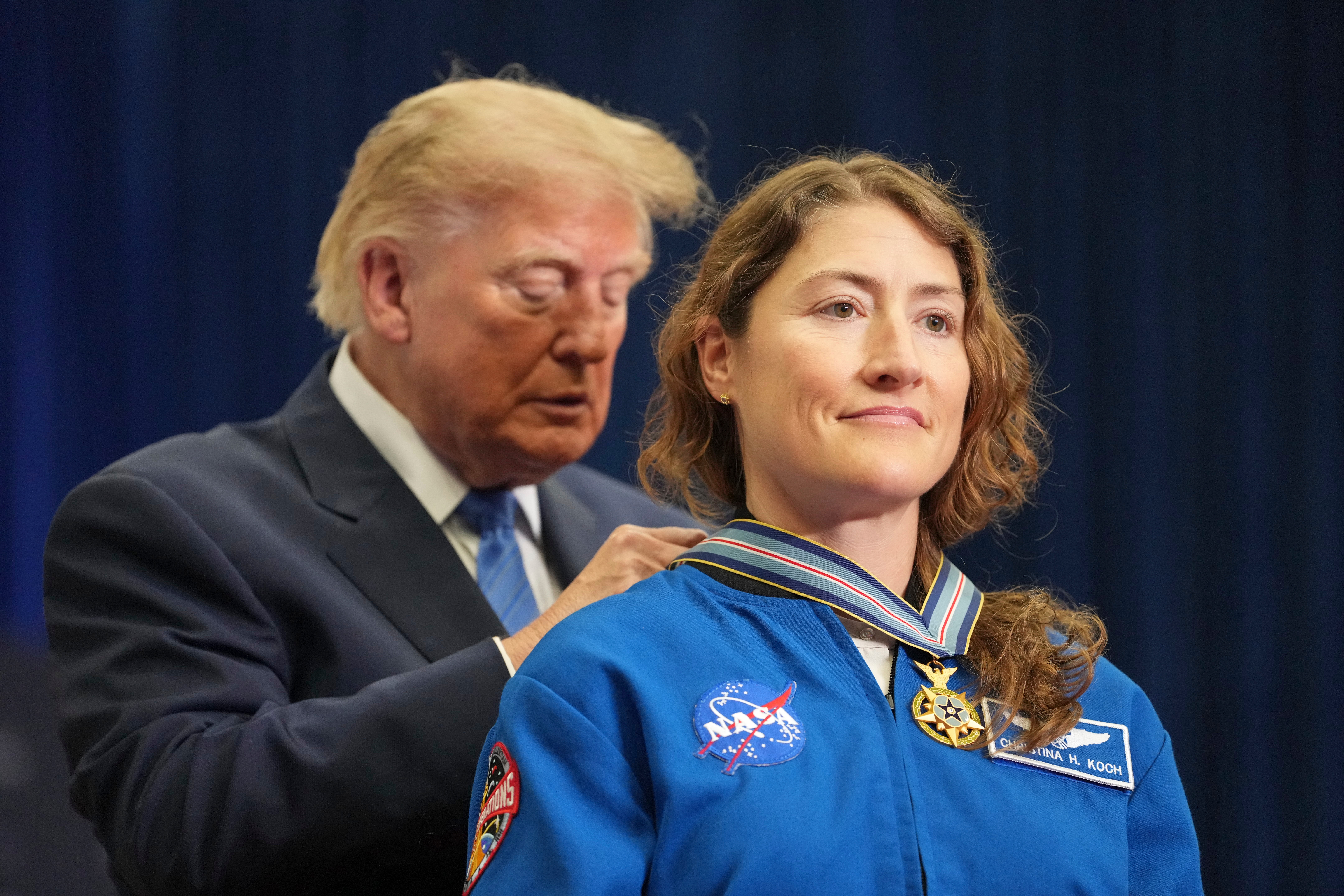 President Donald Trump, left, presents the Congressional Space Medal of Honor to Artemis II crew member Christina Koch, Friday, Aug. 28, 2026, at Johnson Space Center in Houston. (AP Photo/Mark Schiefelbein)