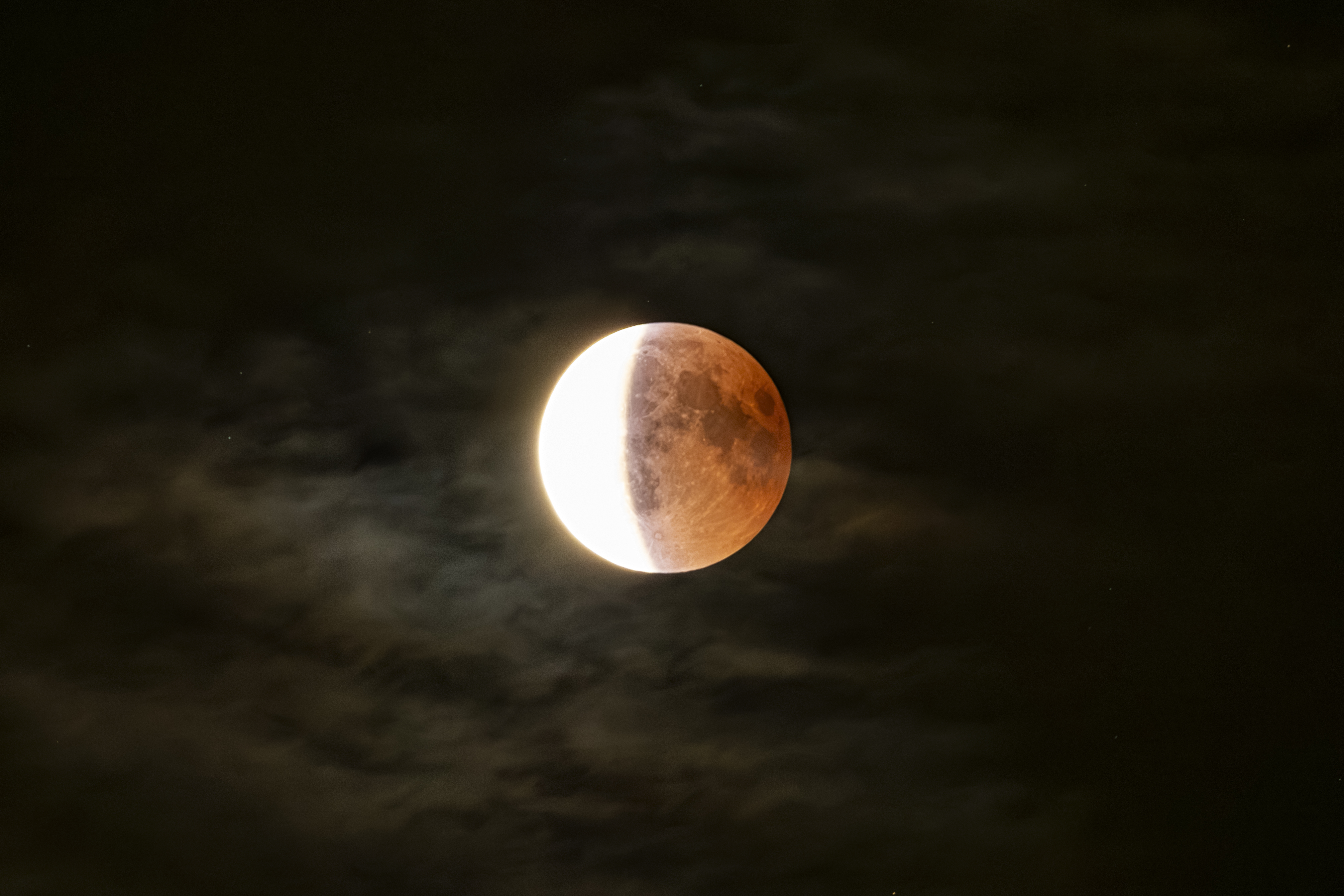 Lunar eclipse close-up in a cloudy night
