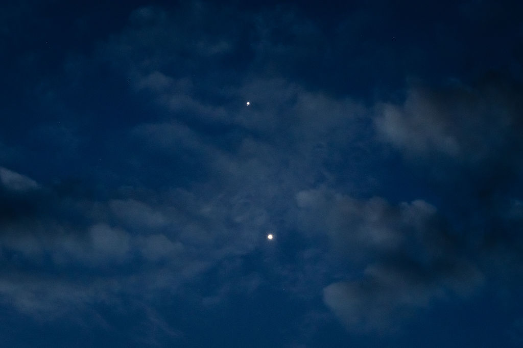 CHONGQING, CHINA - AUGUST 14: Jupiter (top) and Venus (bottom) are seen shining brightly in the eastern sky before sunrise on August 14, 2025, in Chongqing, China. The two planets appeared close together in a celestial event visible to the naked eye, with scattered clouds adding depth to the early morning scene. (Photo by Cheng Xin/Getty Images)