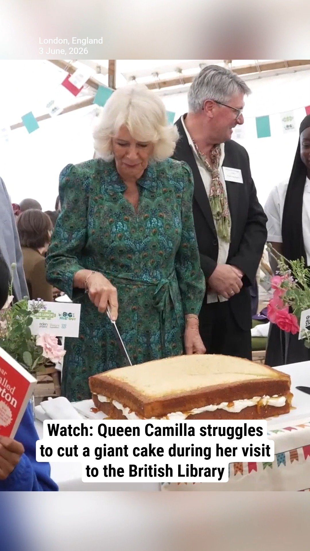 Watch: Queen Camilla struggles to cut a giant cake during her visit to the British Library