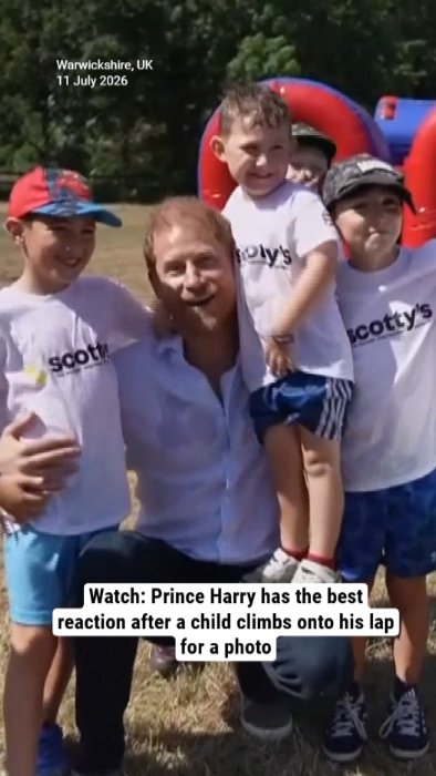 Watch: Prince Harry has the best reaction after a child climbs onto his lap for a photo