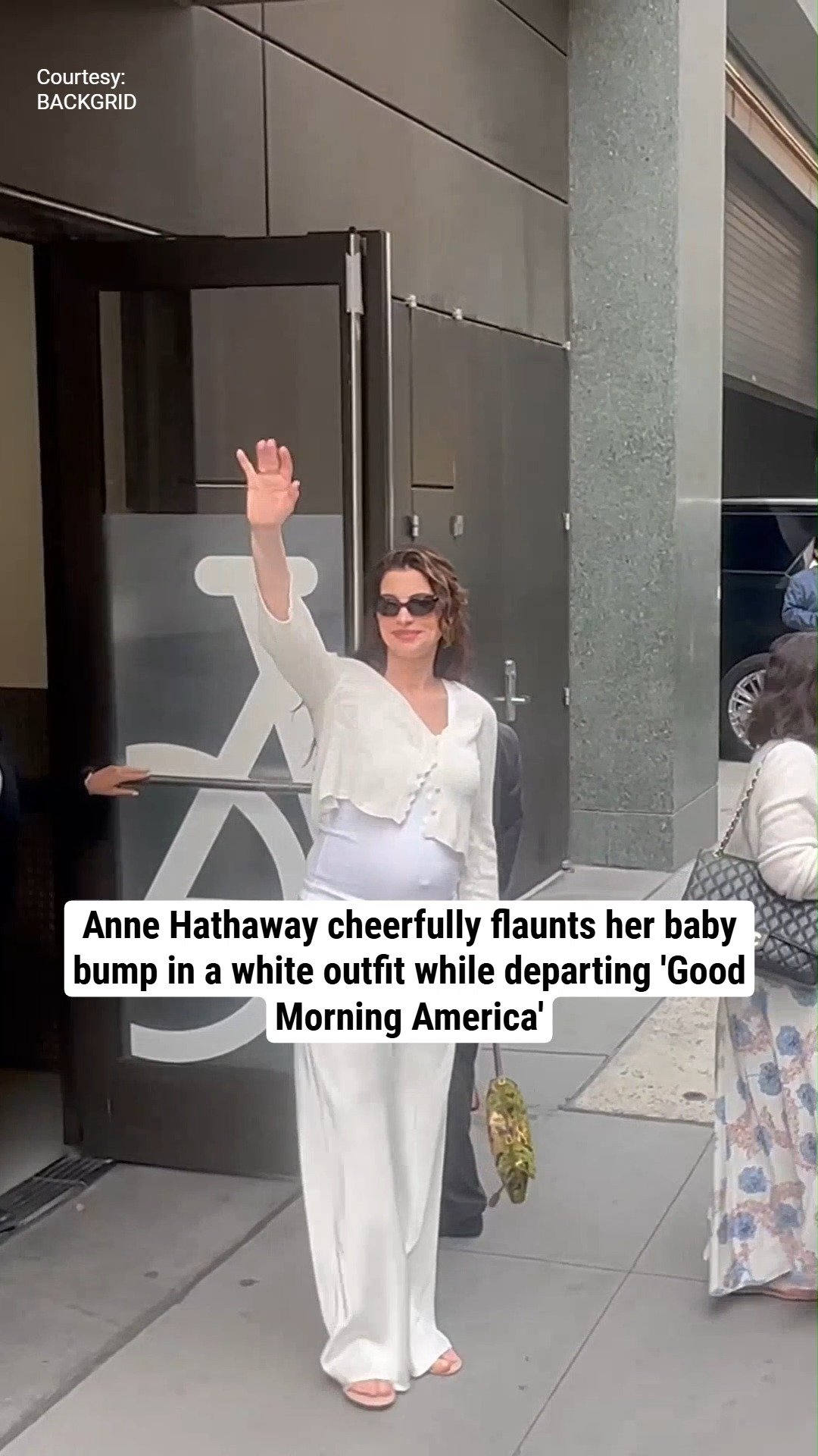 Anne Hathaway cheerfully flaunts her baby bump in a white outfit while departing 'Good Morning America'