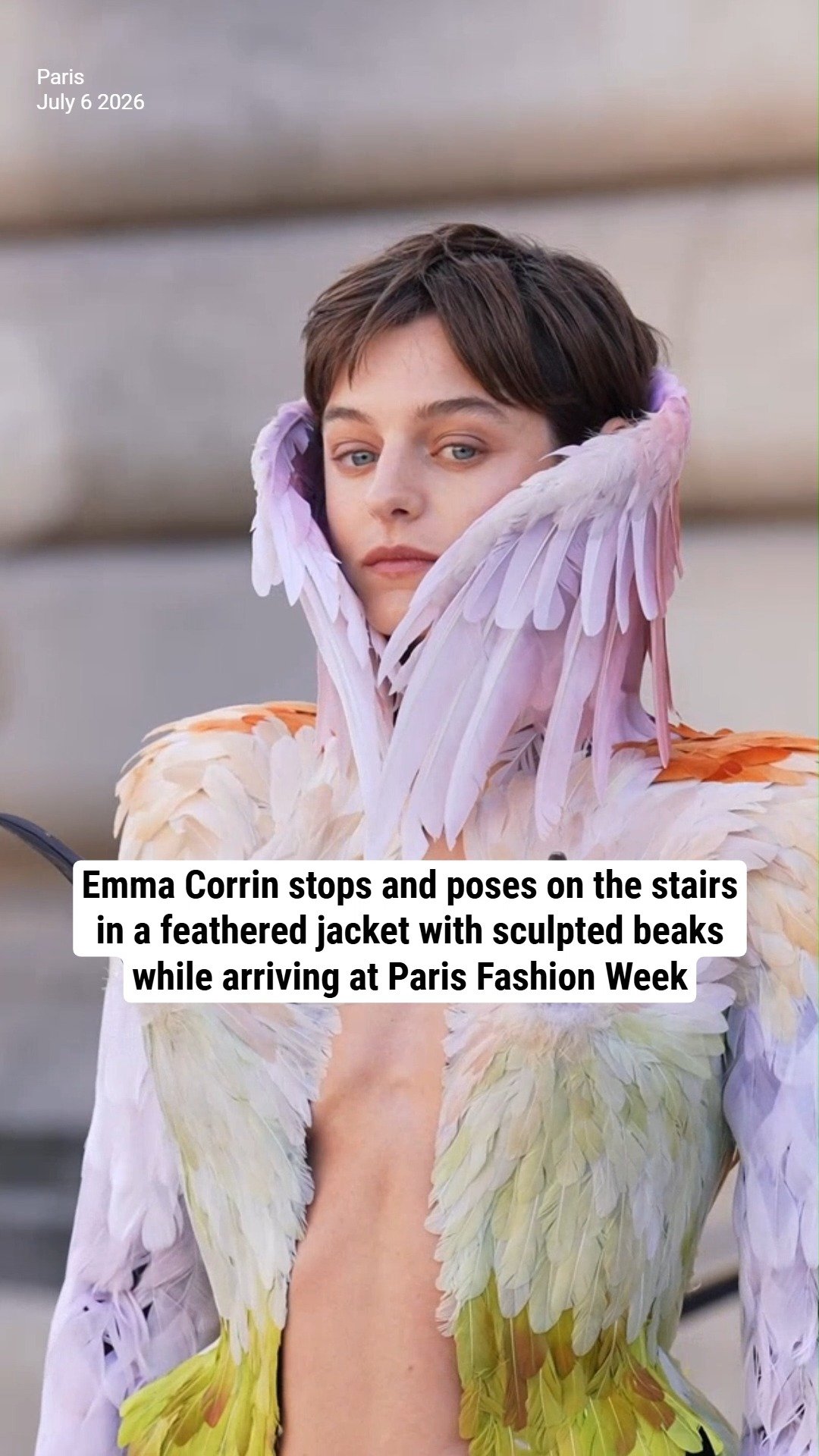 Emma Corrin stops and poses on the stairs in a feathered jacket with sculpted beaks while arriving at Paris Fashion Week