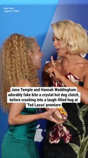 Juno Temple and Hannah Waddingham adorably fake bite a crystal hot dog clutch, before crashing into a laugh-filled hug at 'Ted Lasso' premiere