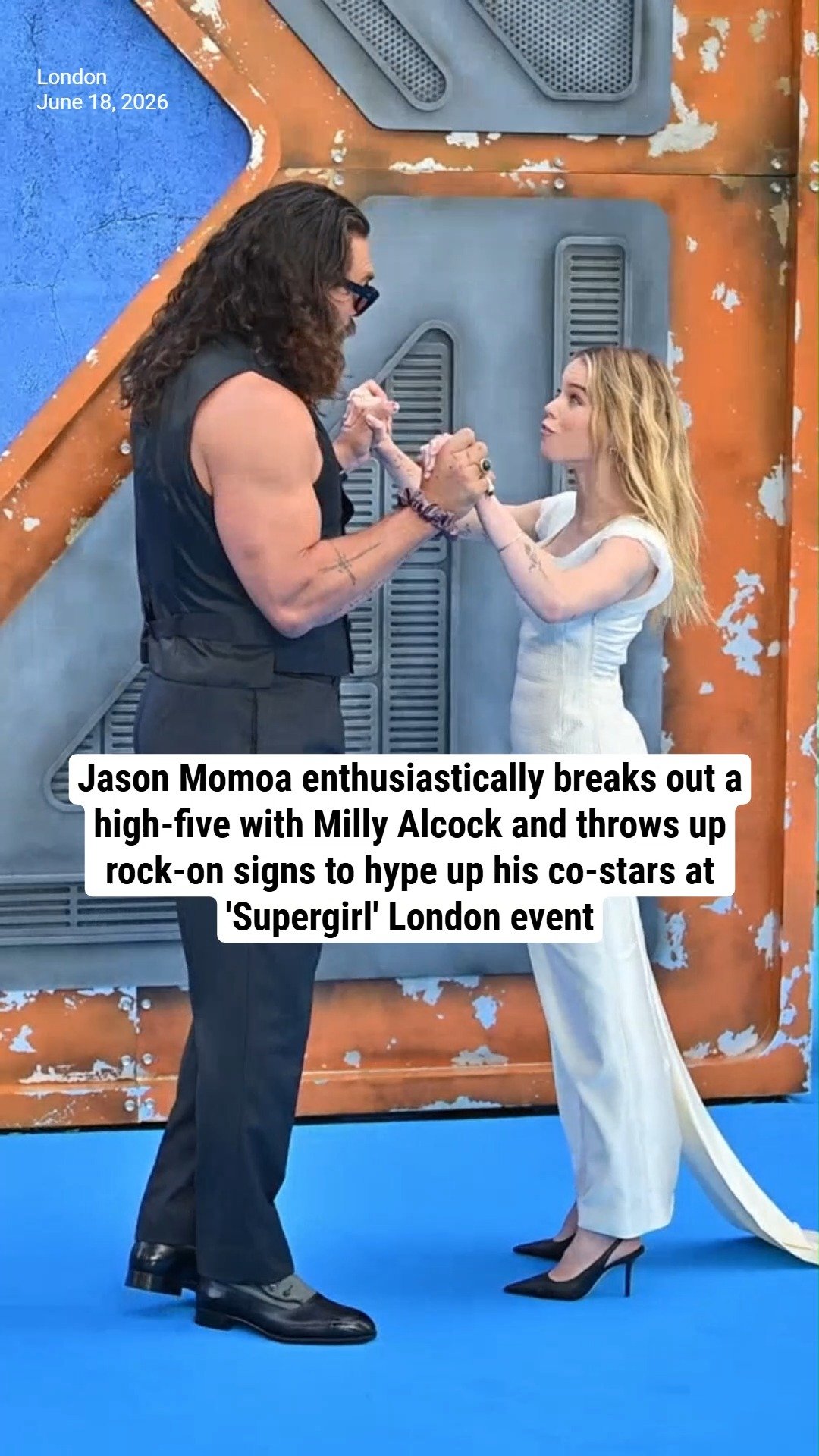 Jason Momoa enthusiastically breaks out a high-five with Milly Alcock and throws up rock-on signs to hype up his co-stars at 'Supergirl' London event