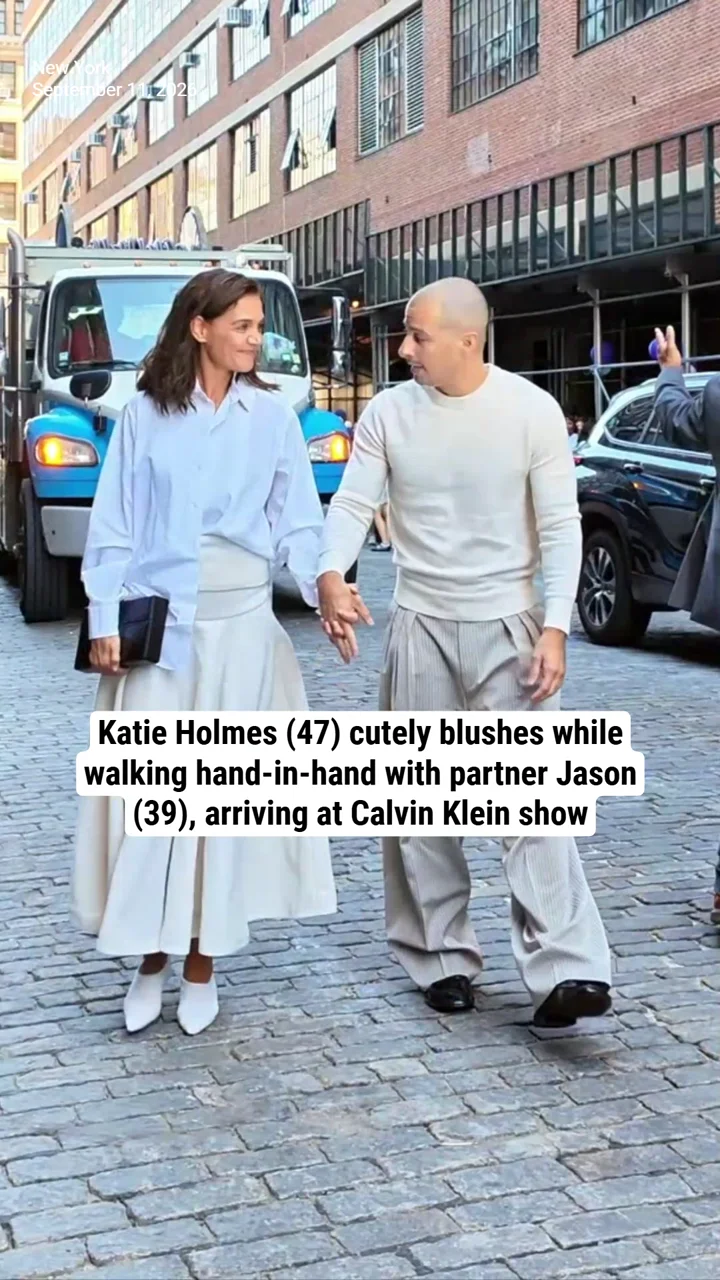 Katie Holmes (47) cutely blushes while walking hand-in-hand with partner Jason (39), arriving at Calvin Klein show
