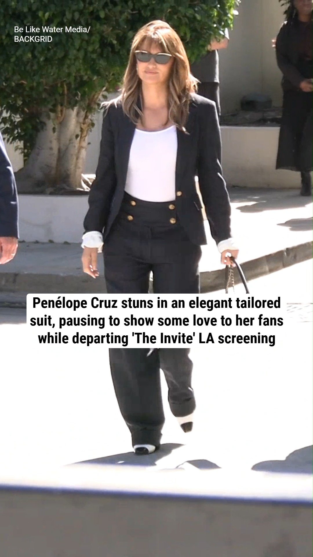 Penélope Cruz stuns in an elegant tailored suit, pausing to show some love to her fans while departing 'The Invite' LA screening