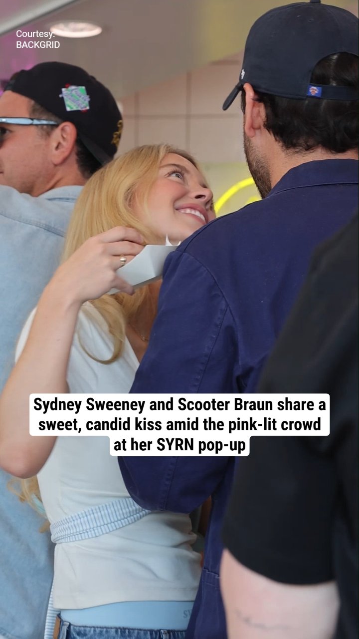 Sydney Sweeney and Scooter Braun share a sweet, candid kiss amid the pink-lit crowd at her SYRN pop-up
