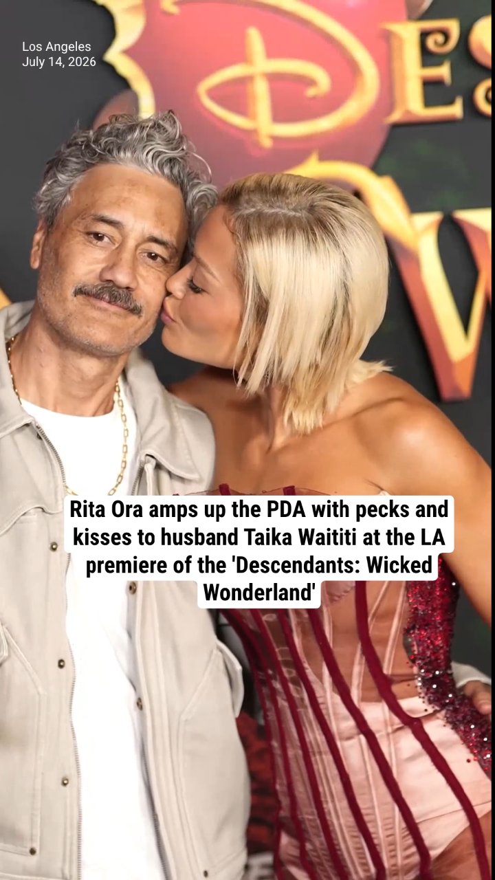 Rita Ora amps up the PDA with pecks and kisses to husband Taika Waititi at the LA premiere of the 'Descendants: Wicked Wonderland'